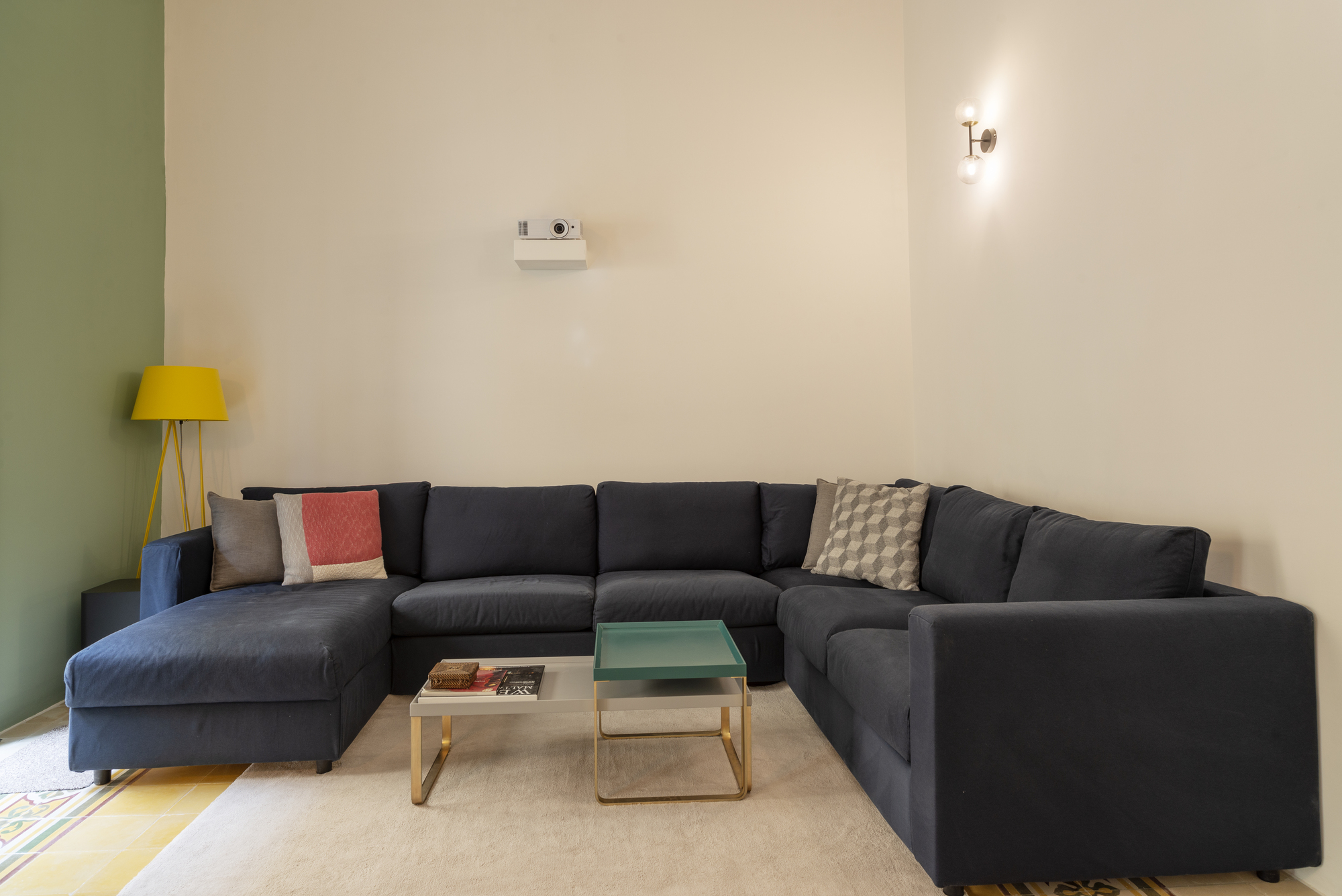 Living room with dark sectional sofa against olive green and cream walls