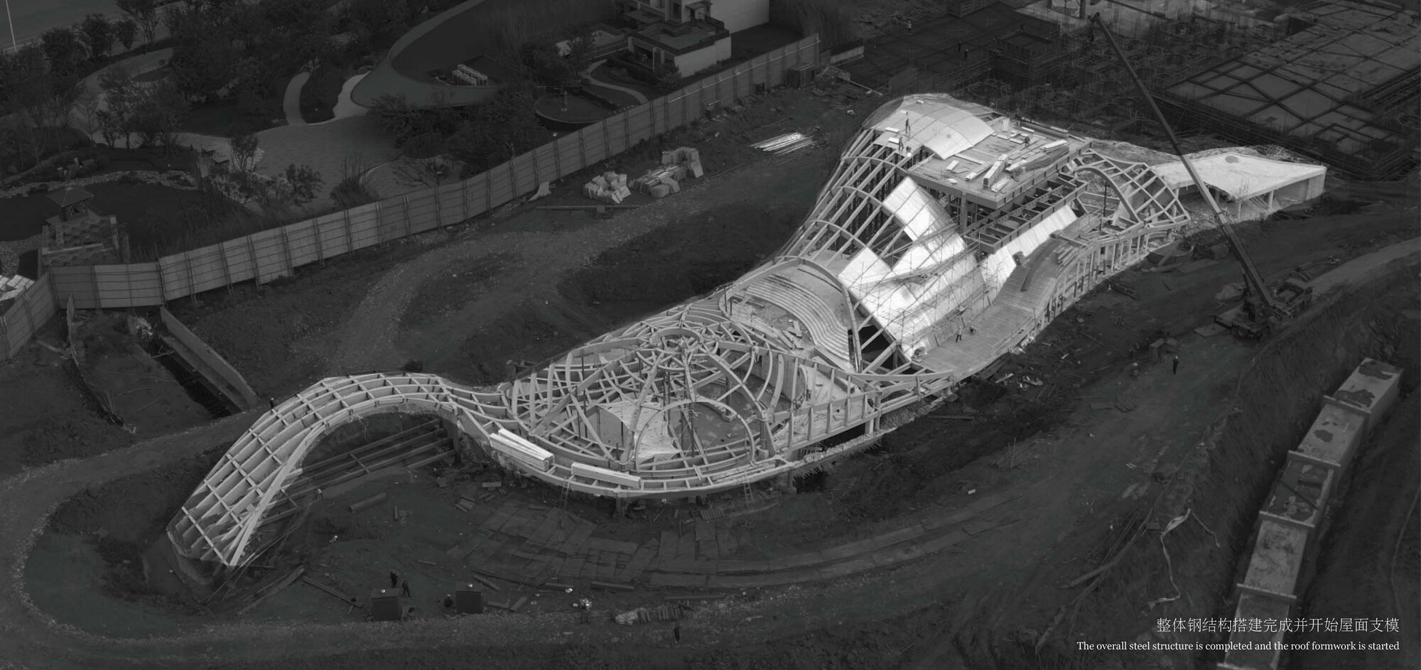 Aerial view of the undulating structural framework with exposed ribs during construction