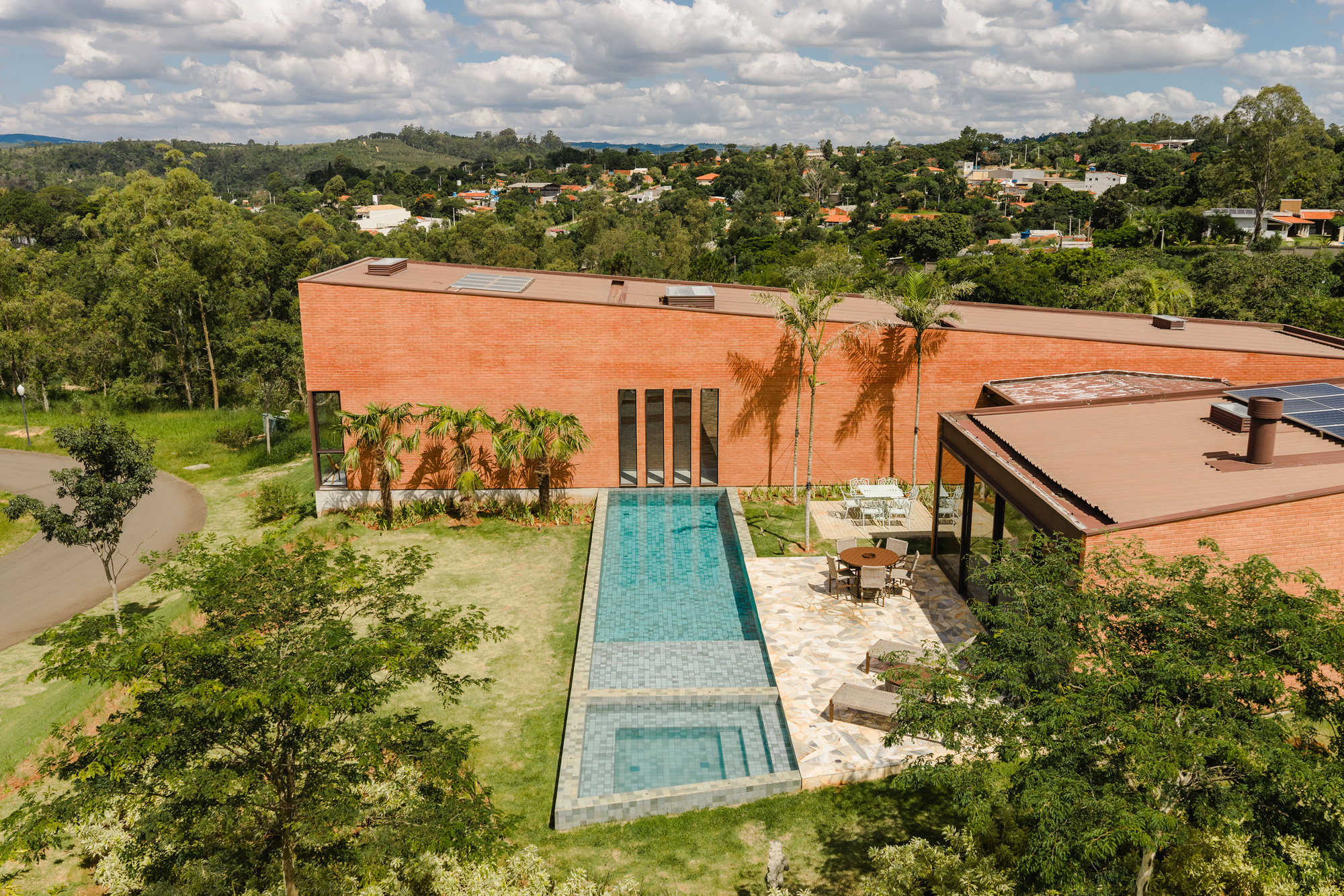Elevated view of the lap pool and terrace with palm trees against the suburban neighborhood backdrop