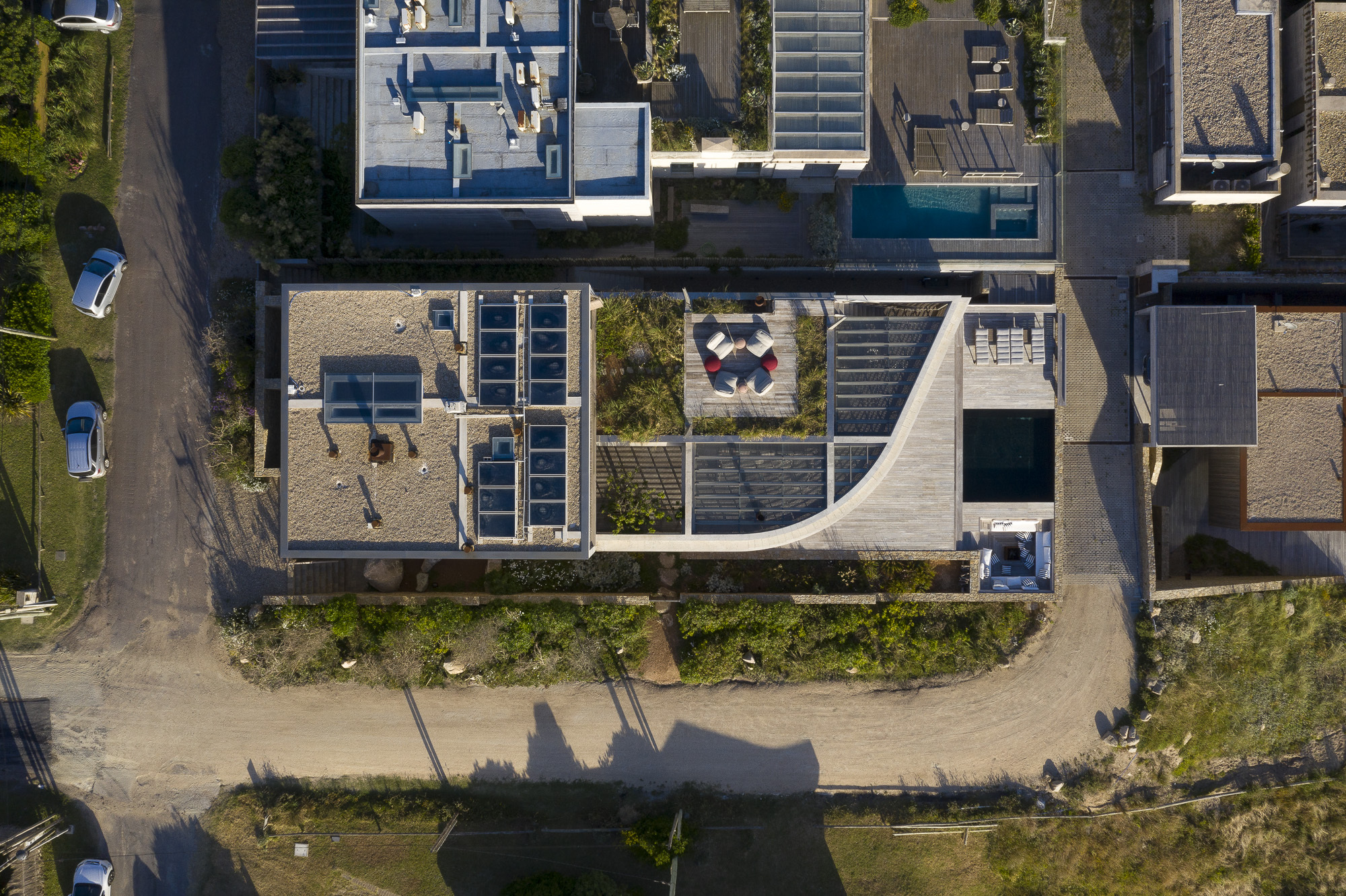Aerial view showing the stepped roof terraces, courtyard plantings, and diagonal site shadows