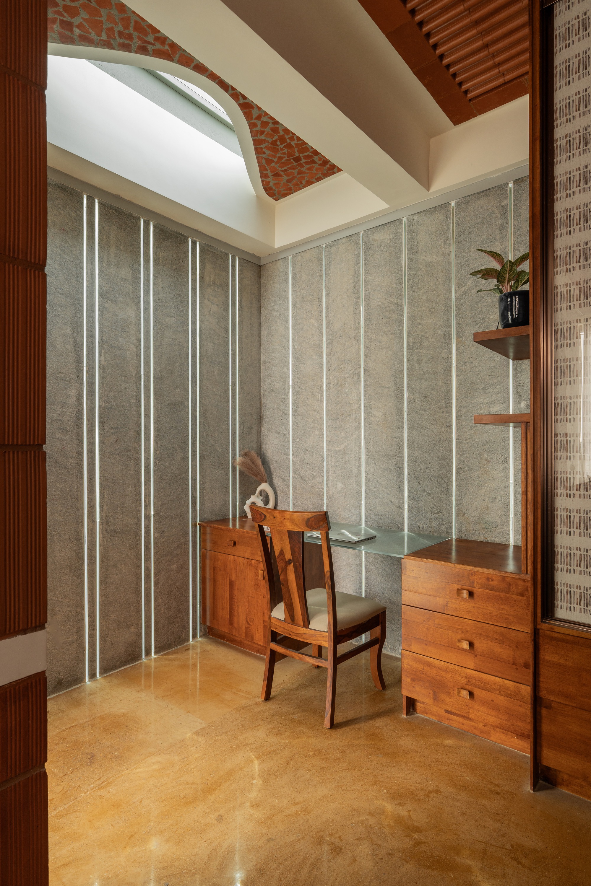 Study alcove showing decorative terracotta panel inset in curved ceiling soffit above workspace