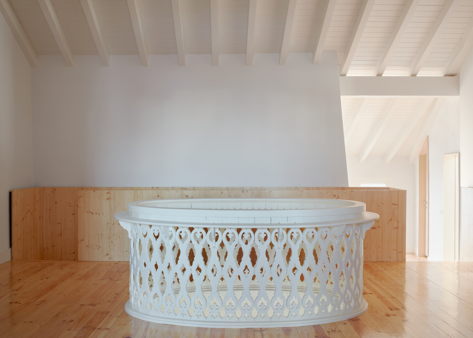 White painted ornamental balustrade with timber backing under an exposed beam ceiling