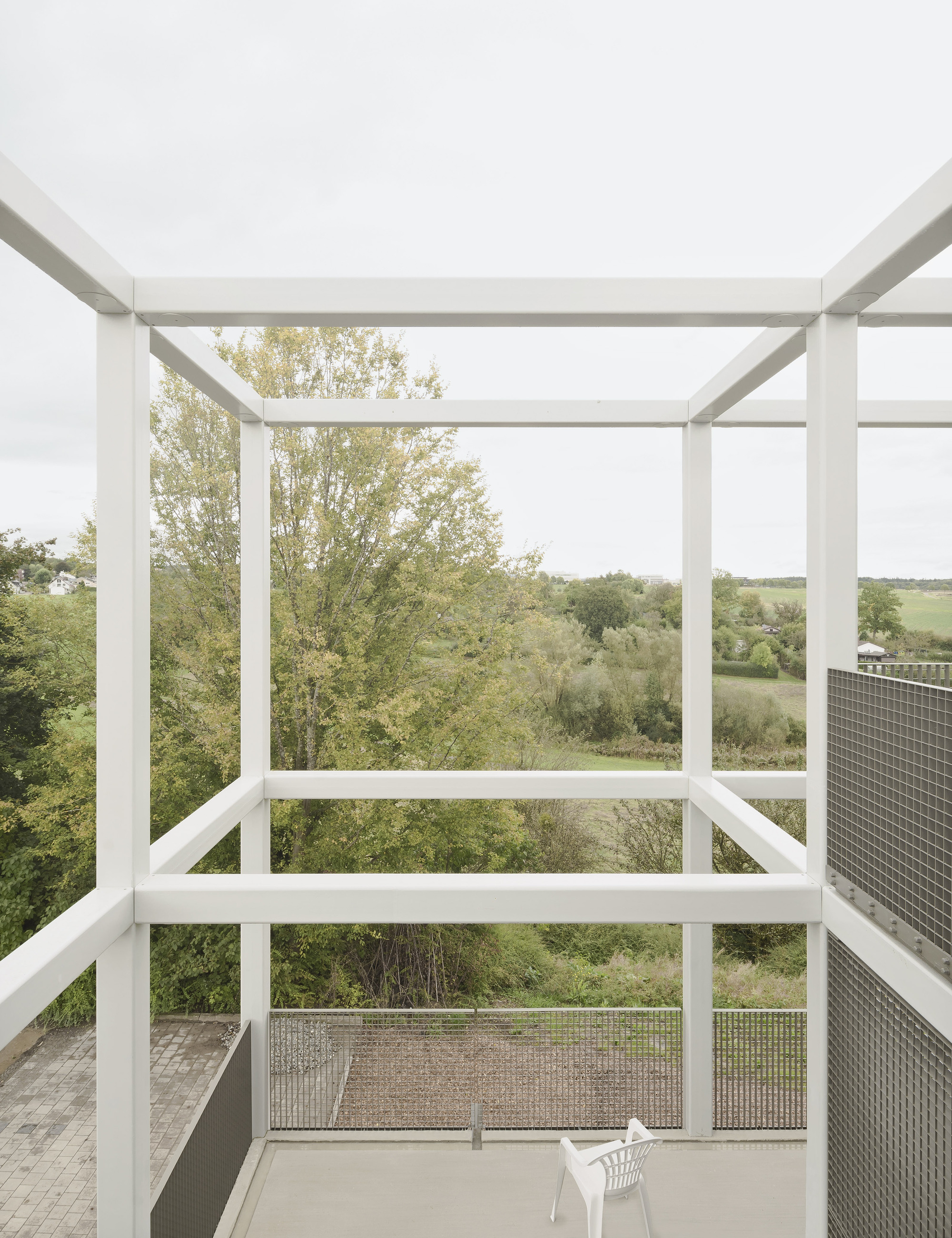 White steel frame pergola on balcony overlooking rolling farmland and trees in autumn foliage