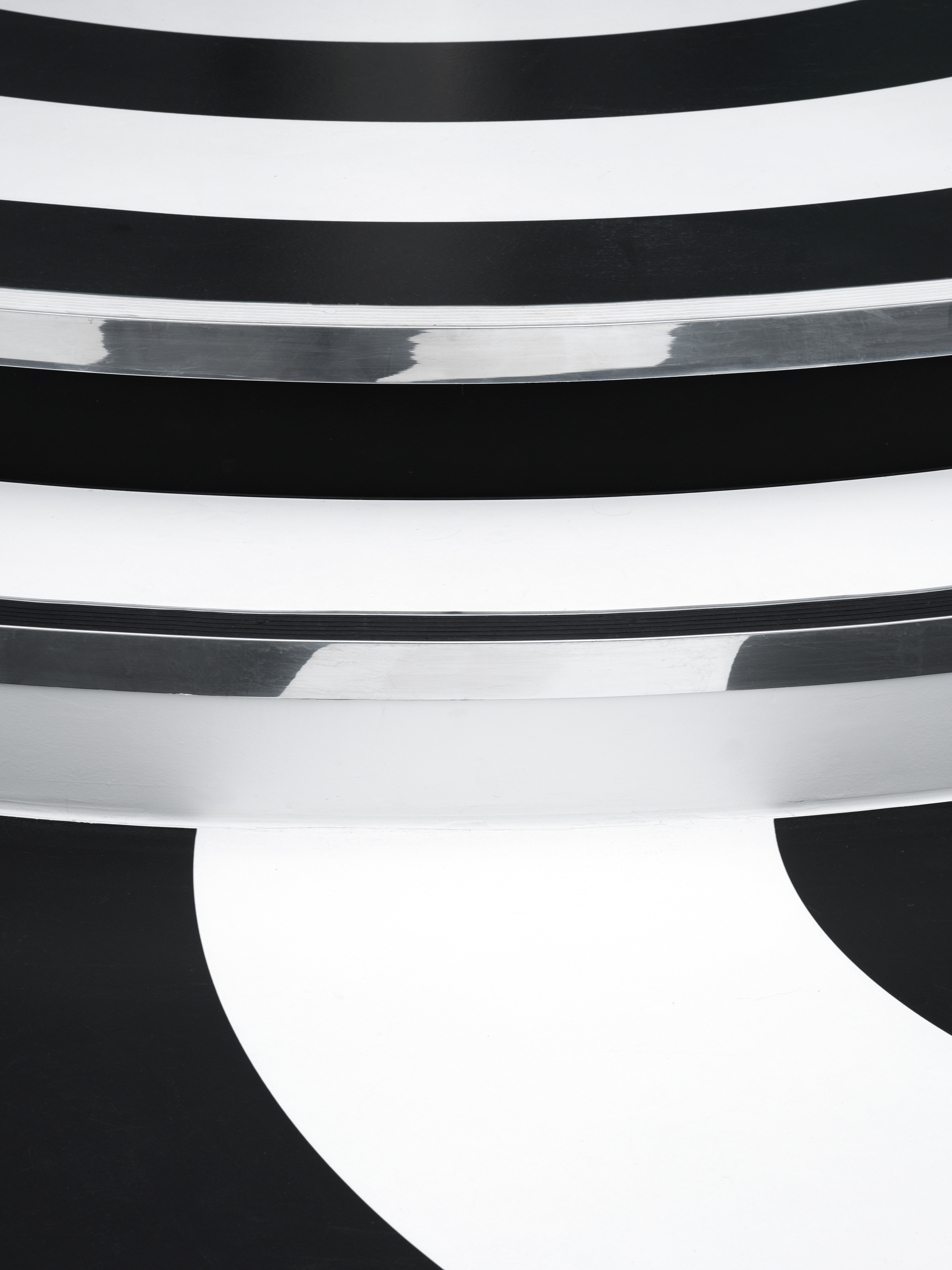 Close-up of curved white plaster balconies stepping down in horizontal bands against dark shadow