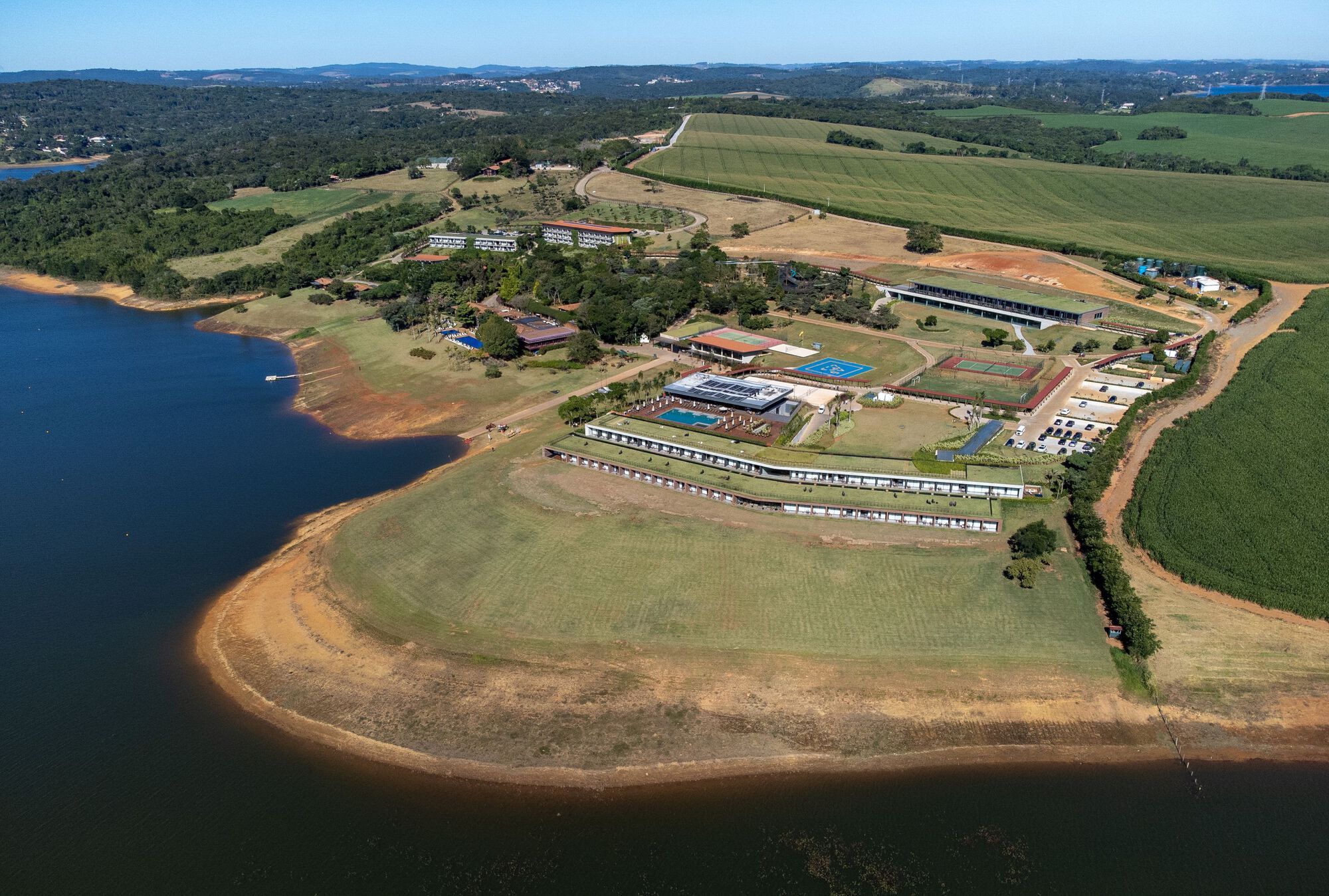 Wide aerial view of the entire resort complex on a peninsula extending into the reservoir