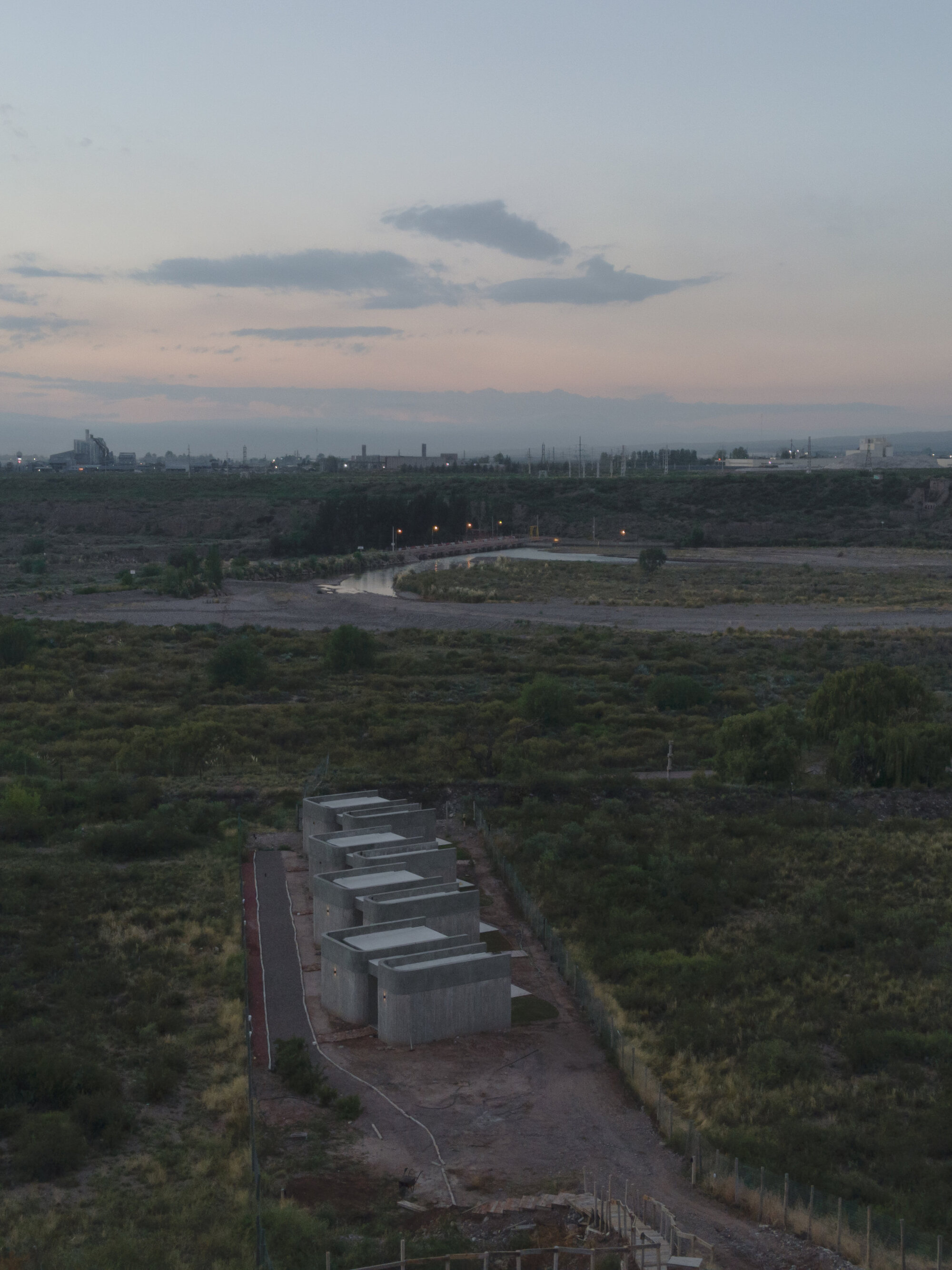 Aerial view of concrete modules arranged along a gravel path at twilight