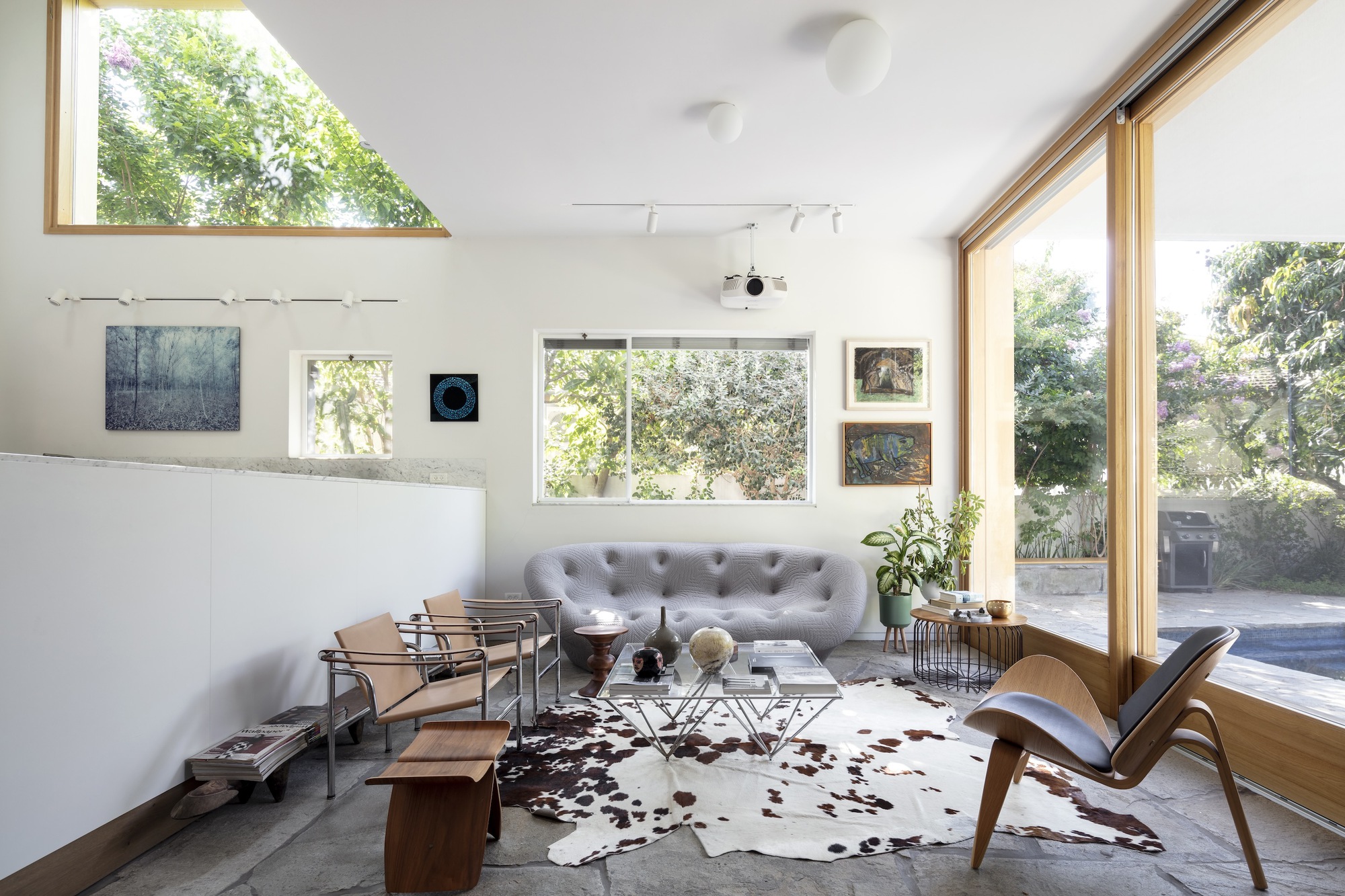 Living room with triangular clerestory window and full-height glazing overlooking the garden