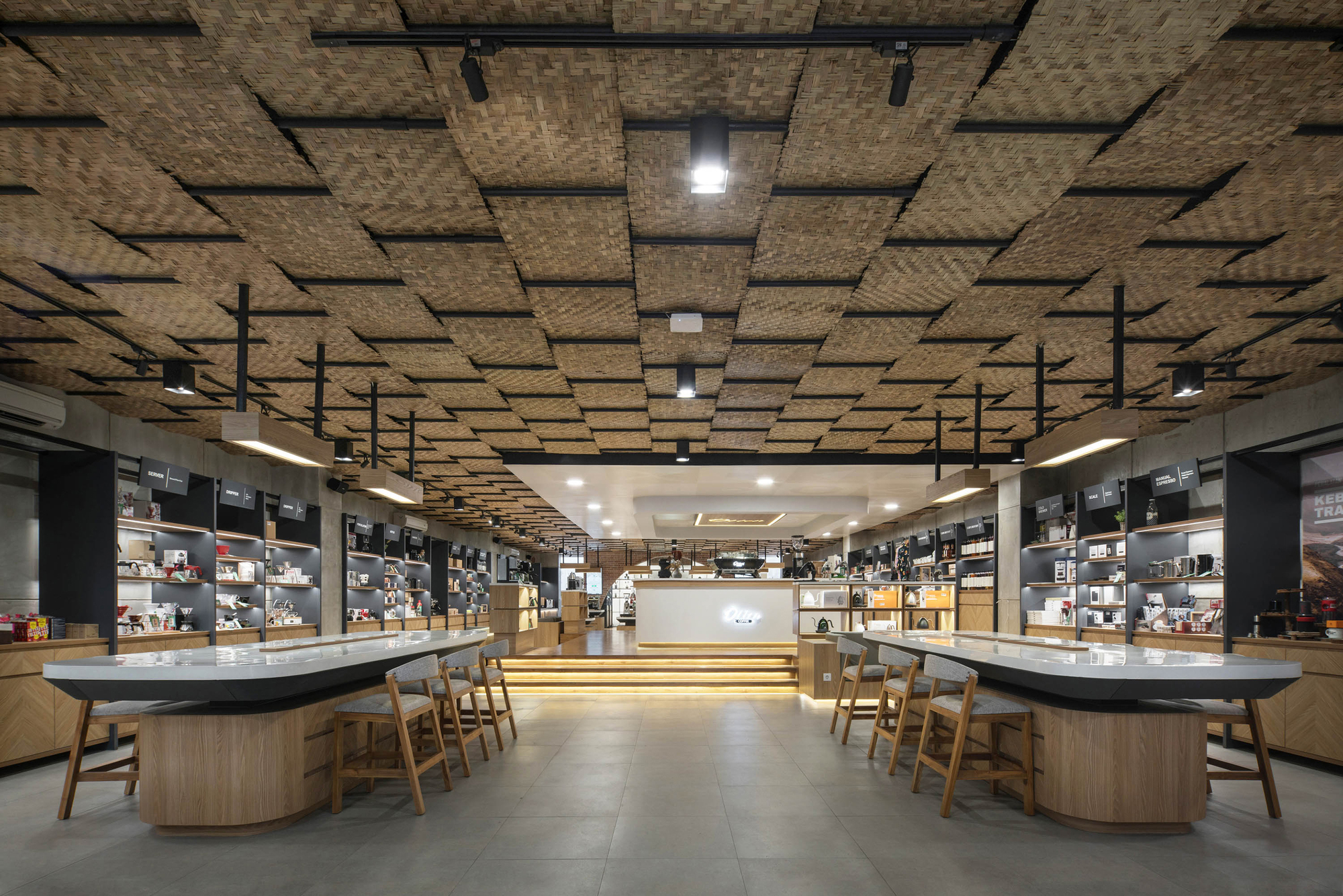 Tasting counter with wooden stools under a suspended woven bamboo ceiling panel system