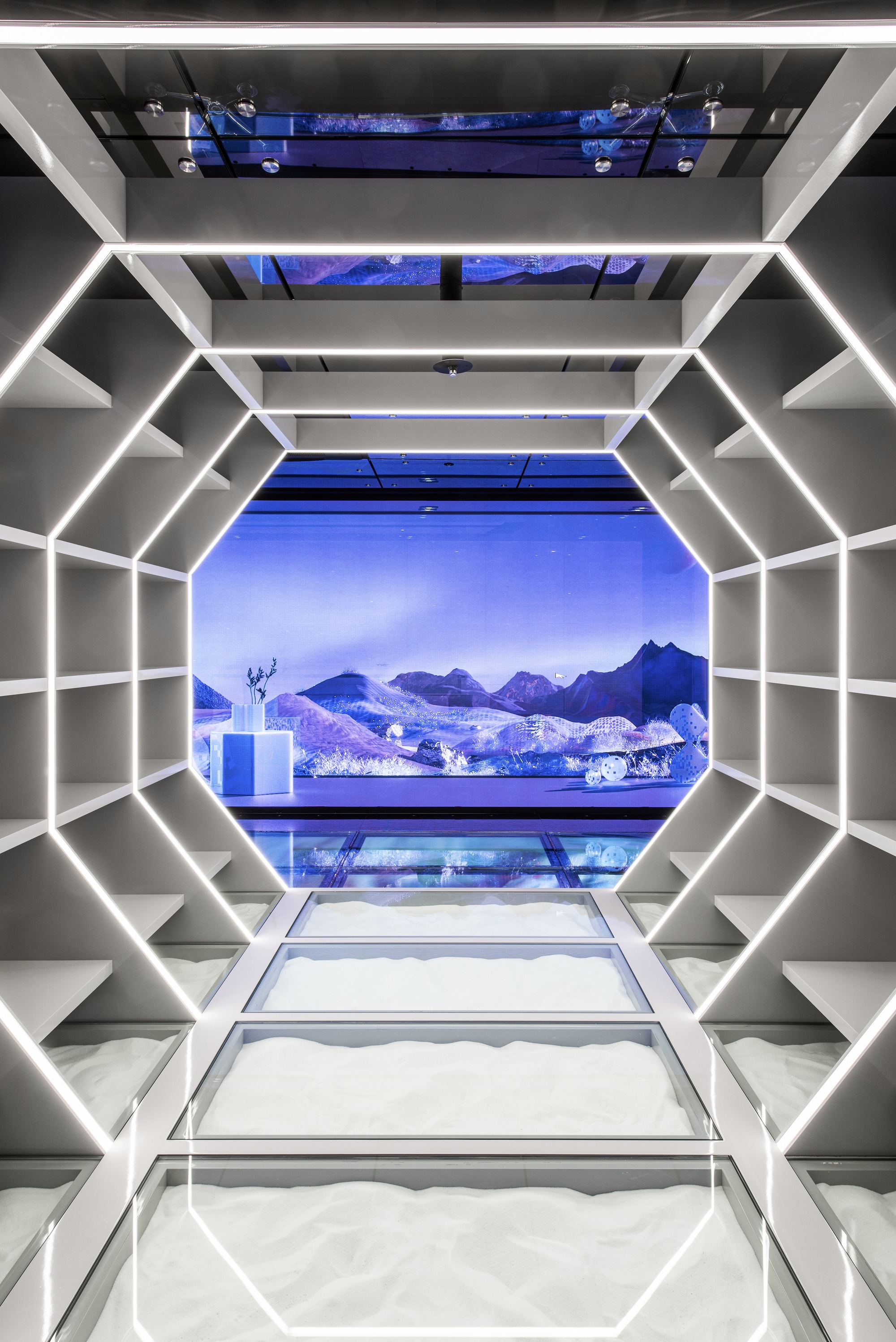 LED-edged octagonal passageway framing a blue projected mountain landscape at its terminus