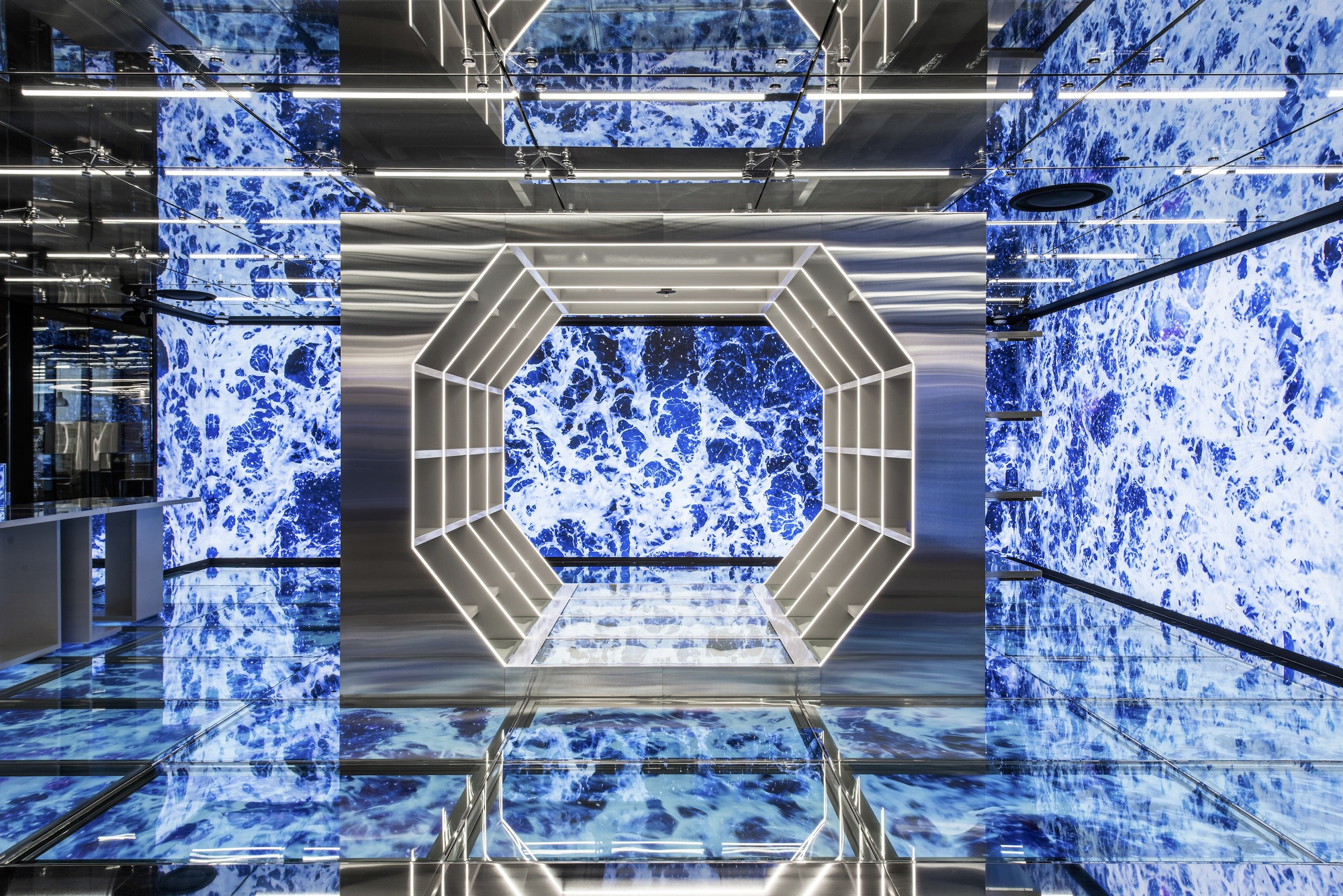Looking up through multi-story atrium with lit octagonal ceiling and blue tiled walls