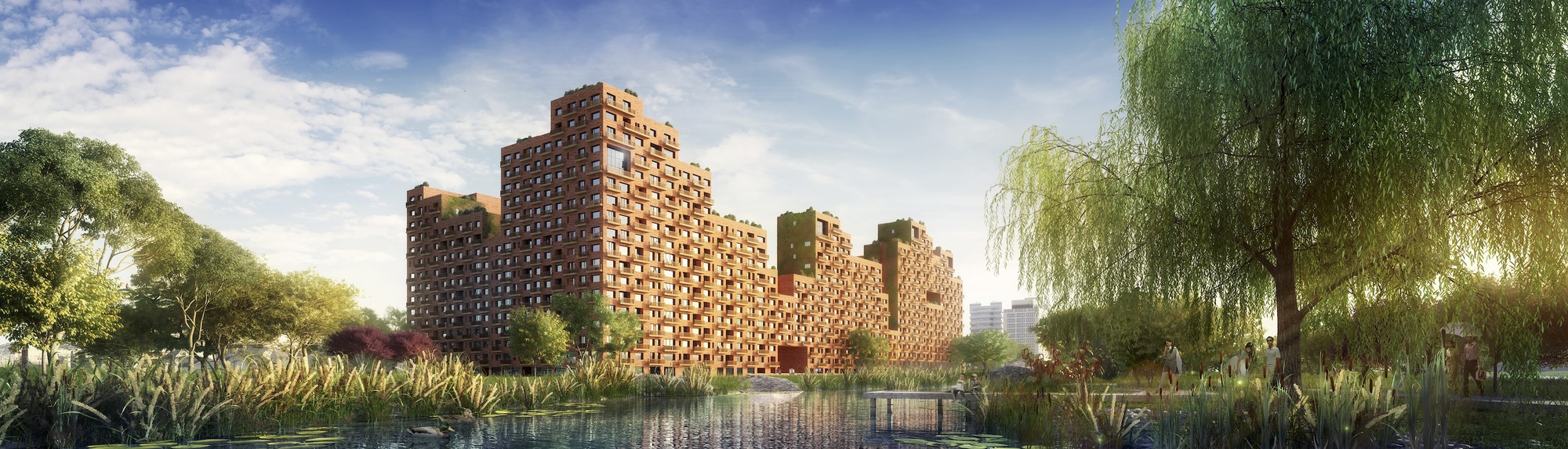 Perforated brick tower complex viewed across a reflecting pond with willow trees and planted beds