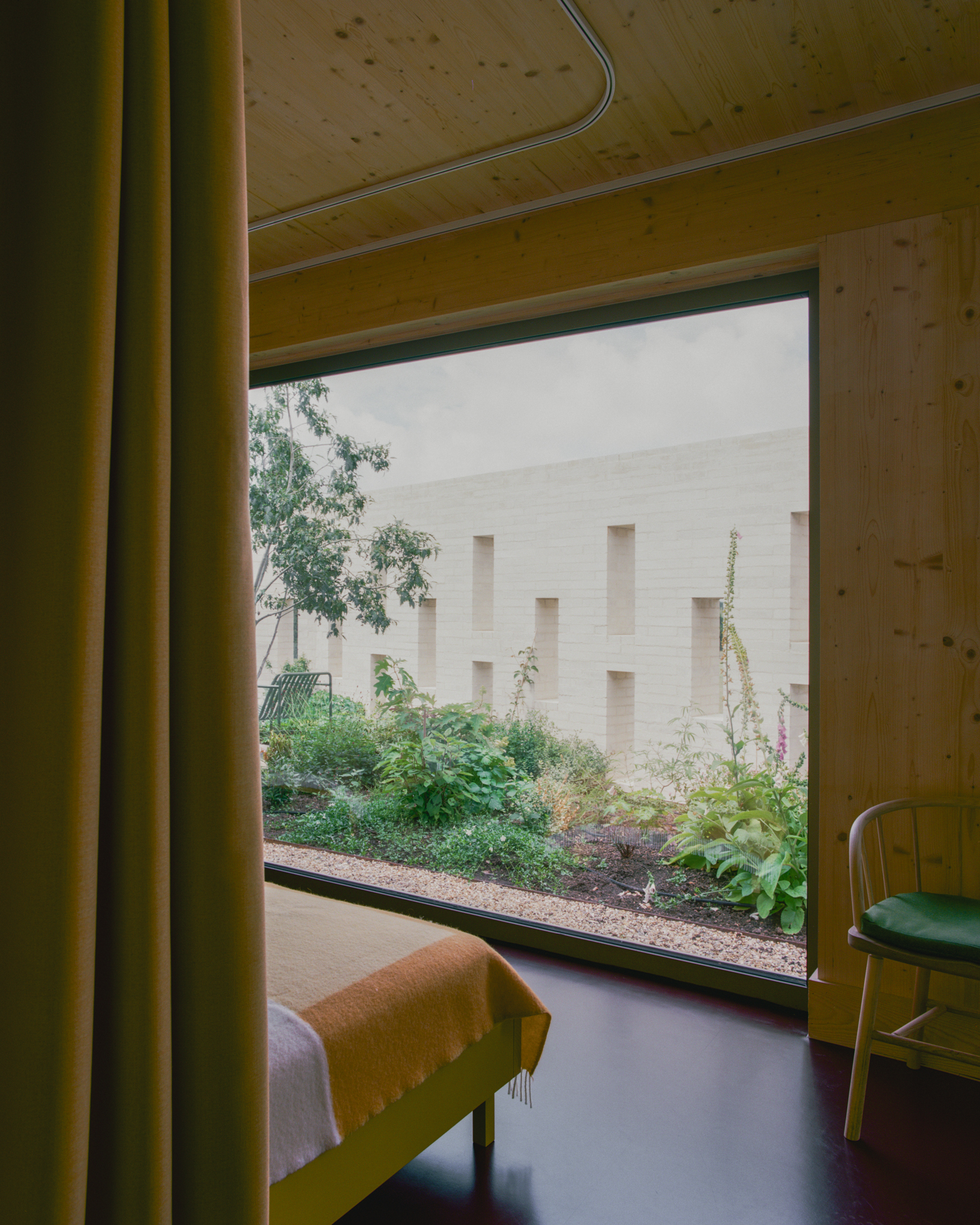 Window seat looking out to a shared garden with pale brickwork facade visible beyond