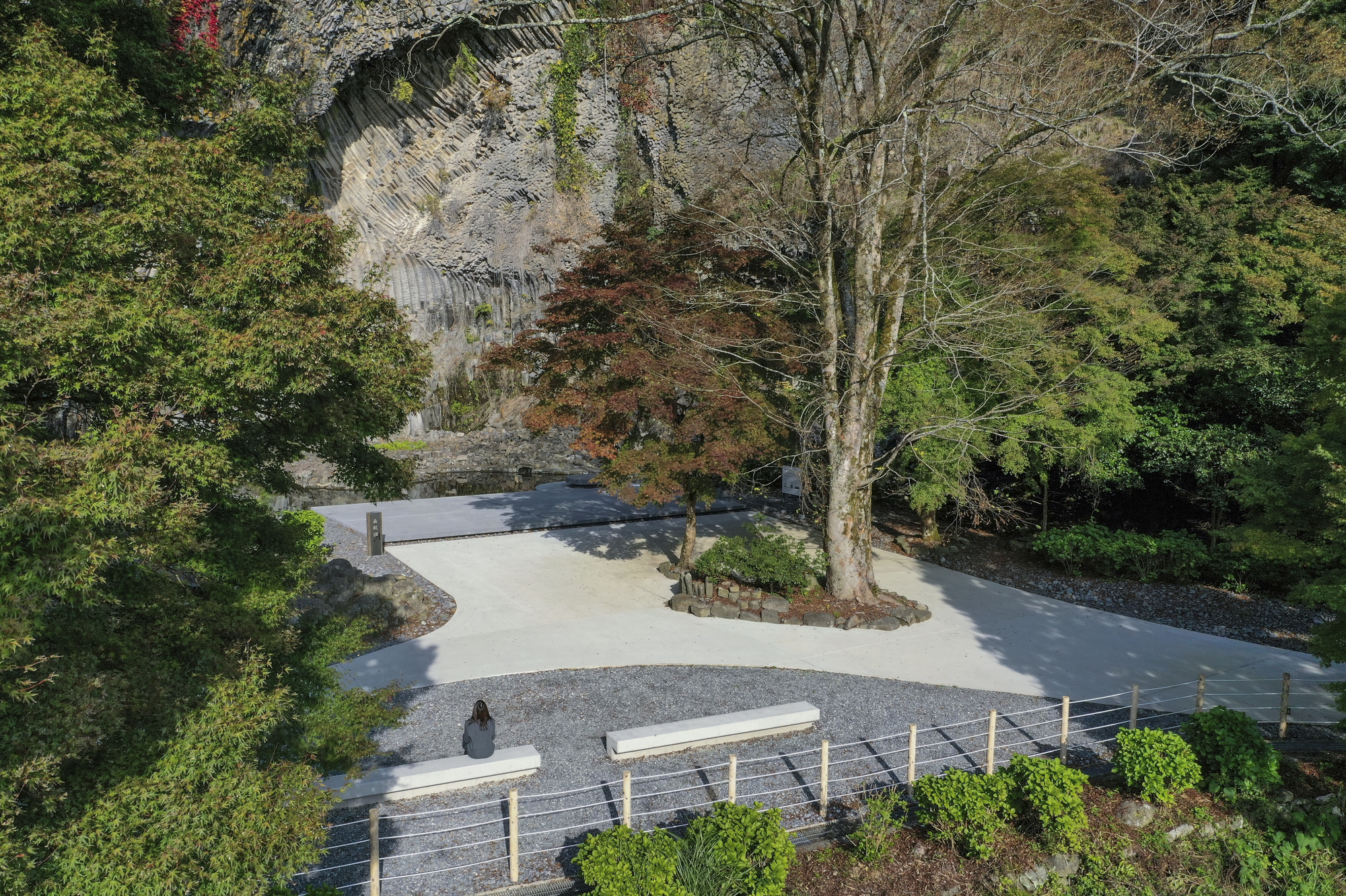 Branching concrete paths surrounding a planted circle with deciduous trees in autumn foliage