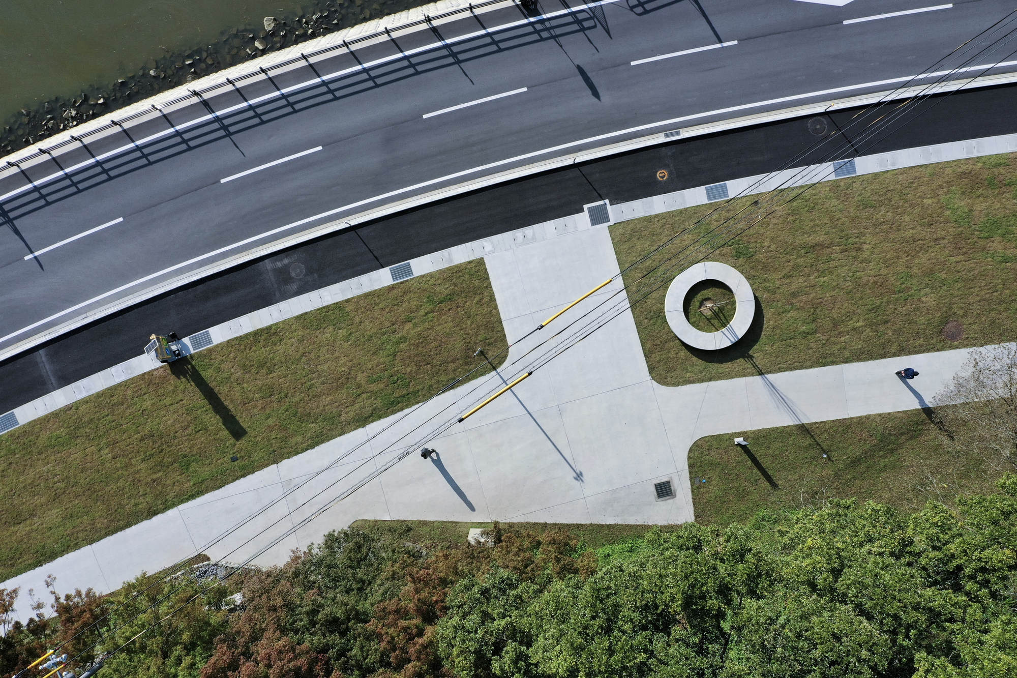 Aerial view of the concrete plaza intersecting roadway and lawn with circular planted opening