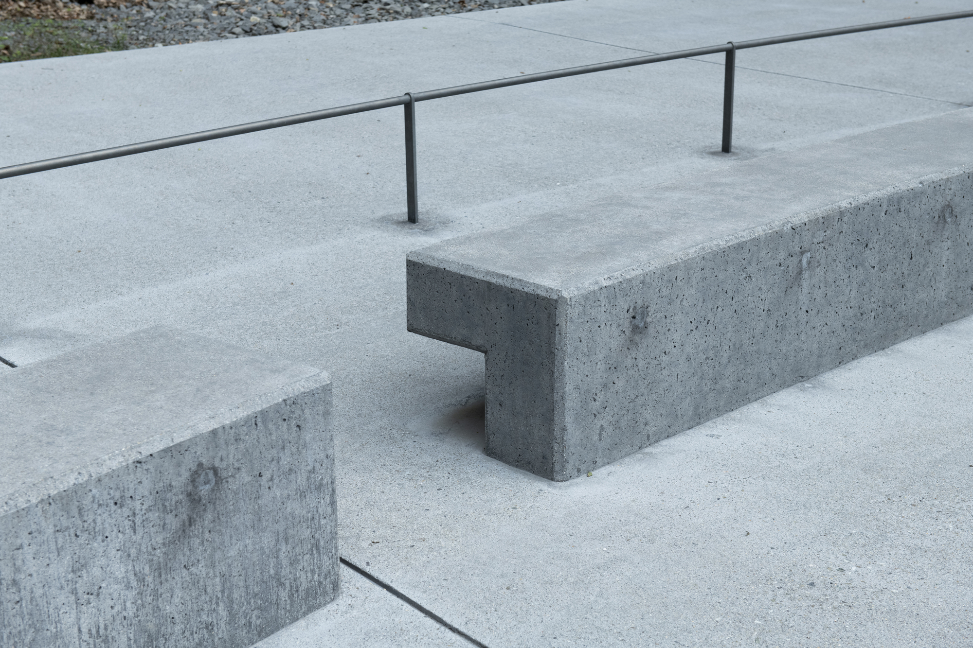 Detail of cast concrete bench with notched corner joint and steel railing posts