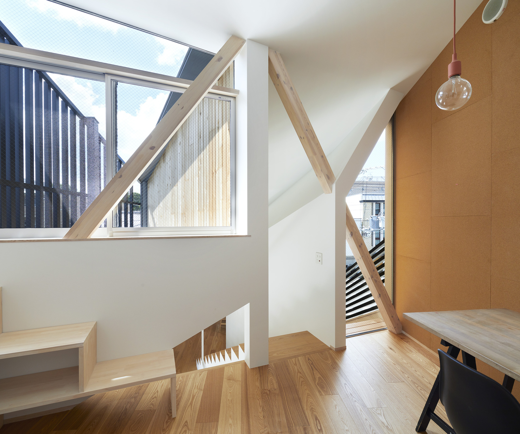 Upper landing with diagonal timber beam and glazed skylight overlooking the stairwell and courtyard