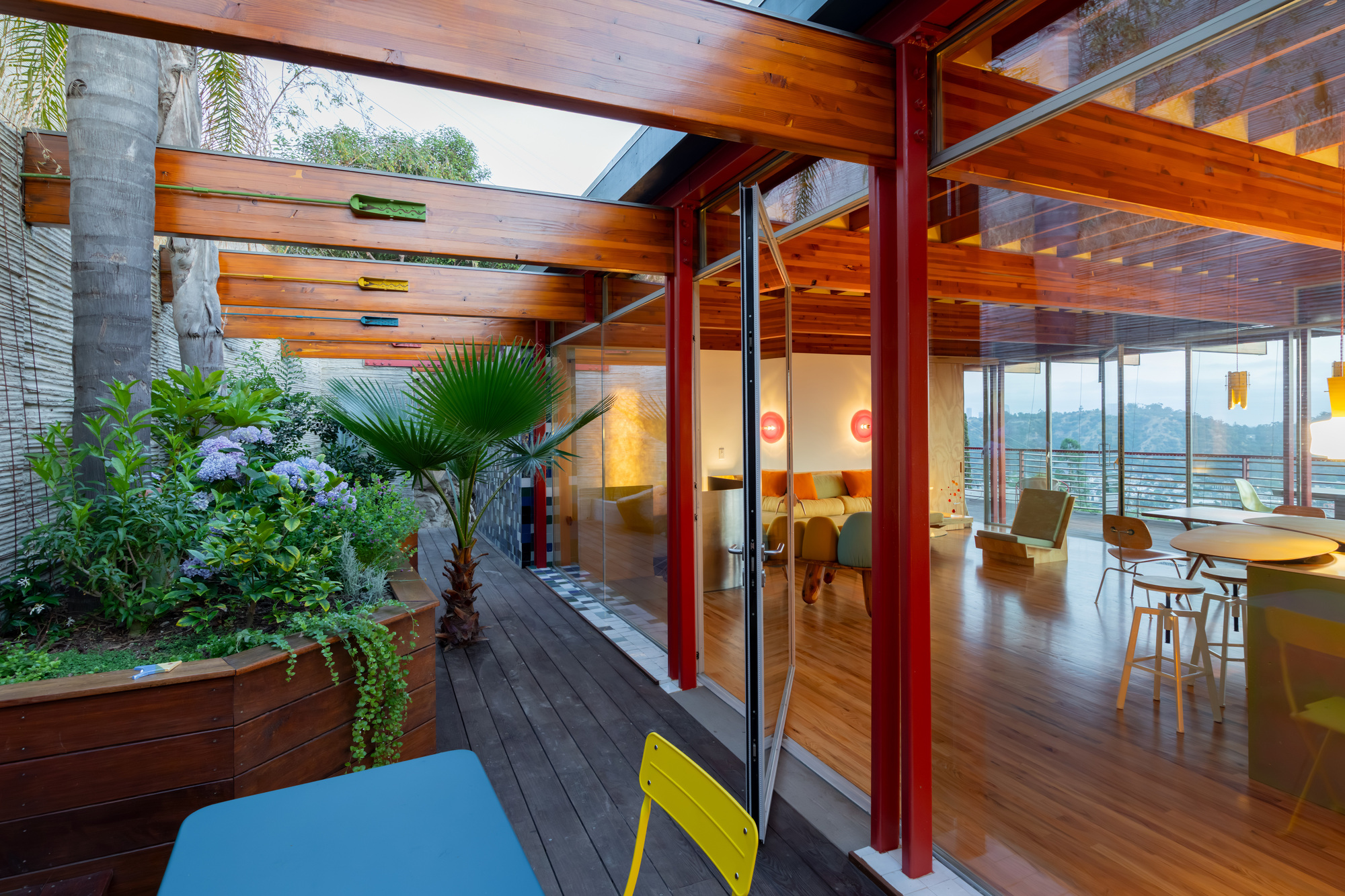 Interior courtyard with planted palms and ferns opening to the living space at twilight