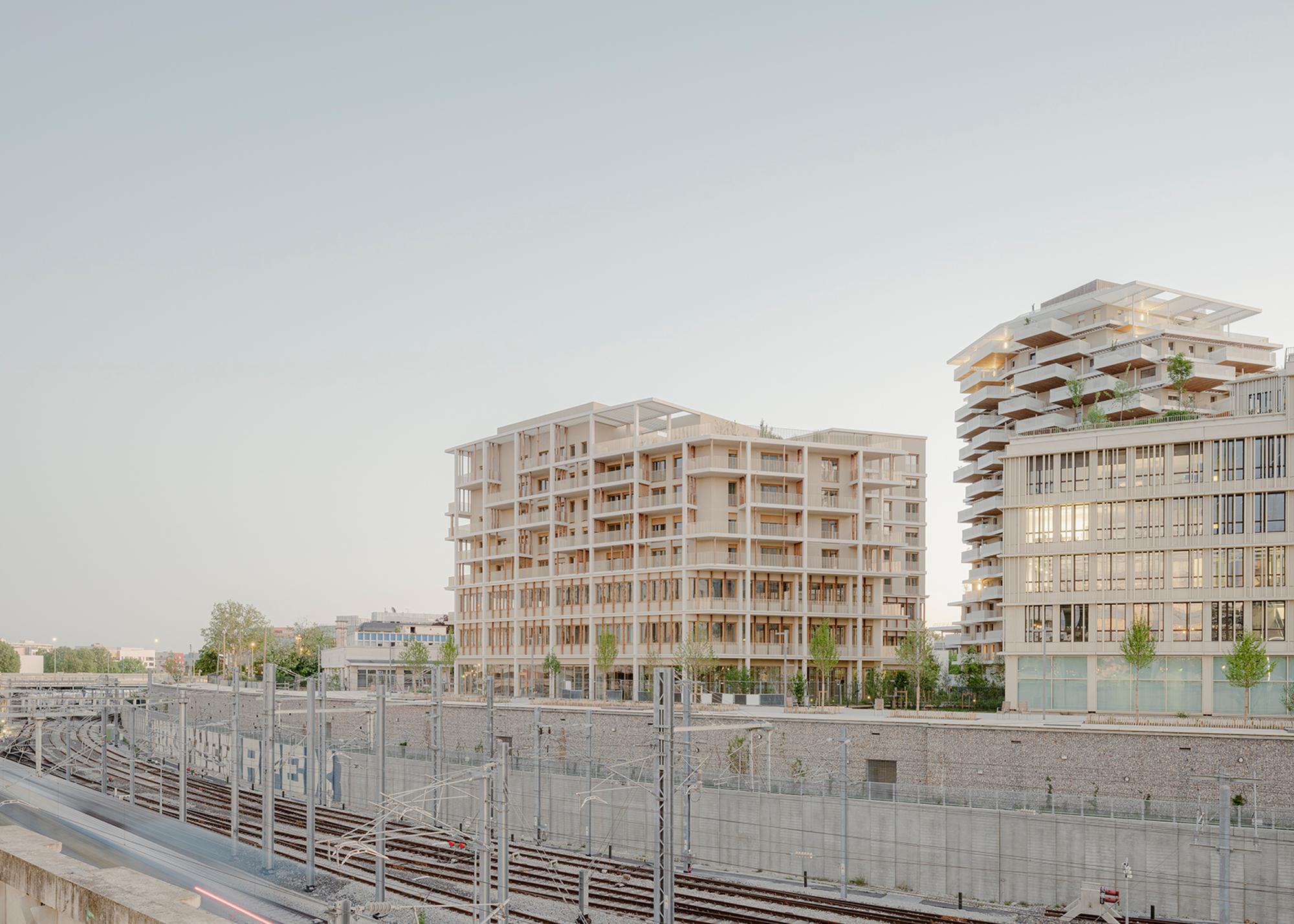 View of the timber-framed residential buildings from the railway tracks under an overcast sky