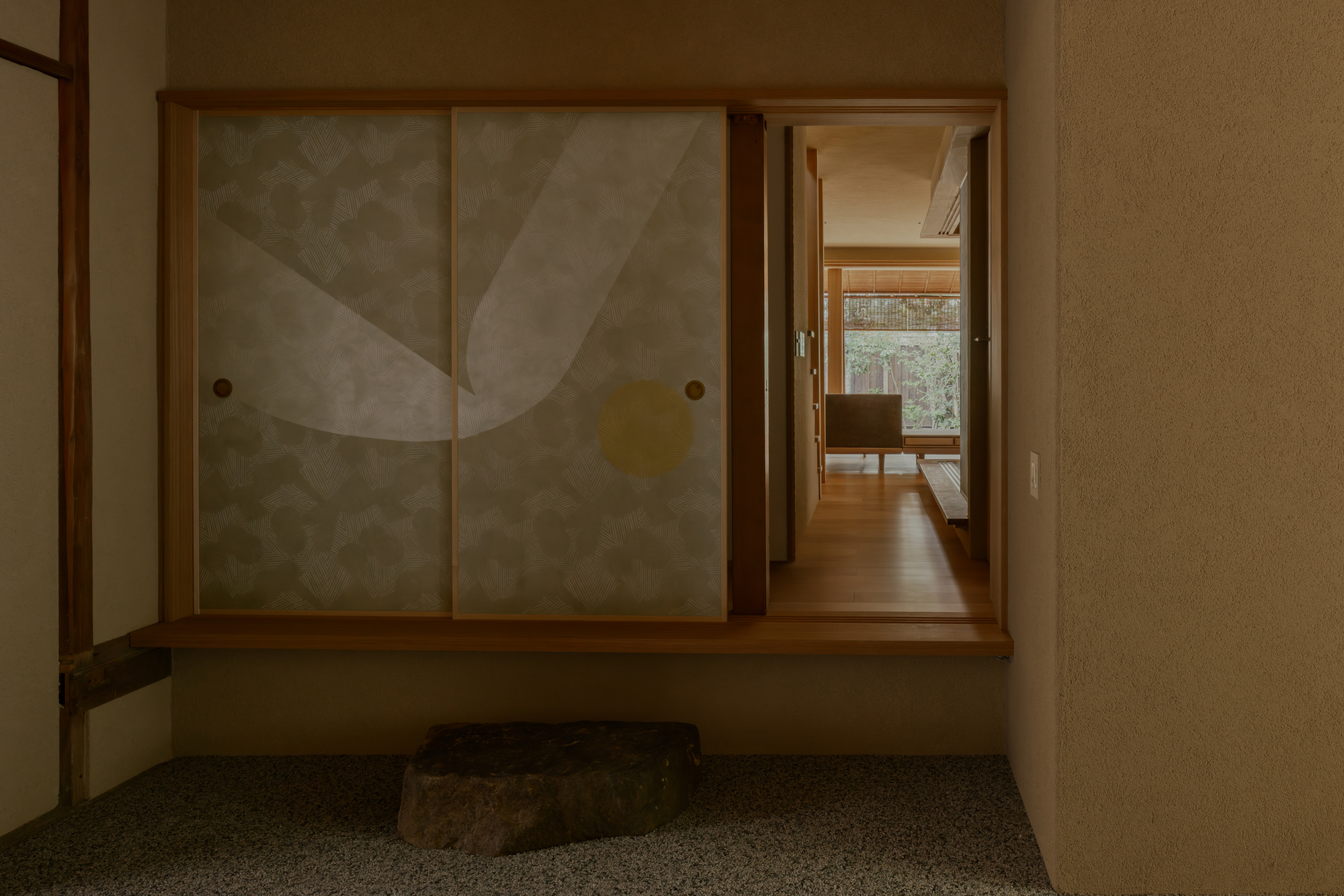 Entryway with translucent sliding doors, timber framing, and stone accent in terrazzo floor