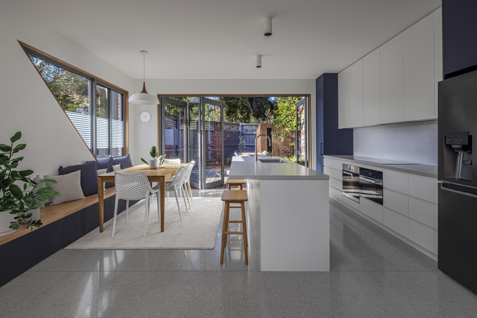 Interior view of the kitchen island and dining area with angular clerestory window above