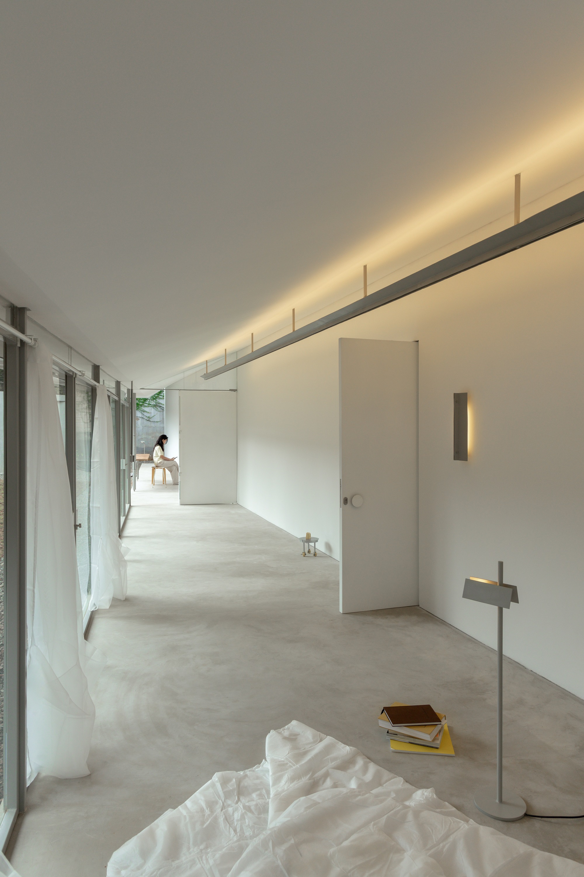 Interior corridor with polished concrete floor and continuous linear cove lighting along the ceiling