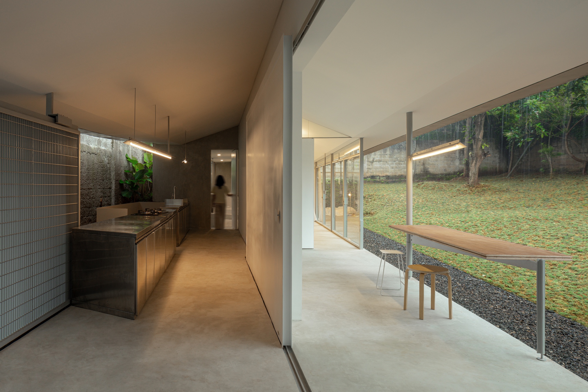 Kitchen and dining area with steel cabinetry and mesh screen opening to the lawn beyond