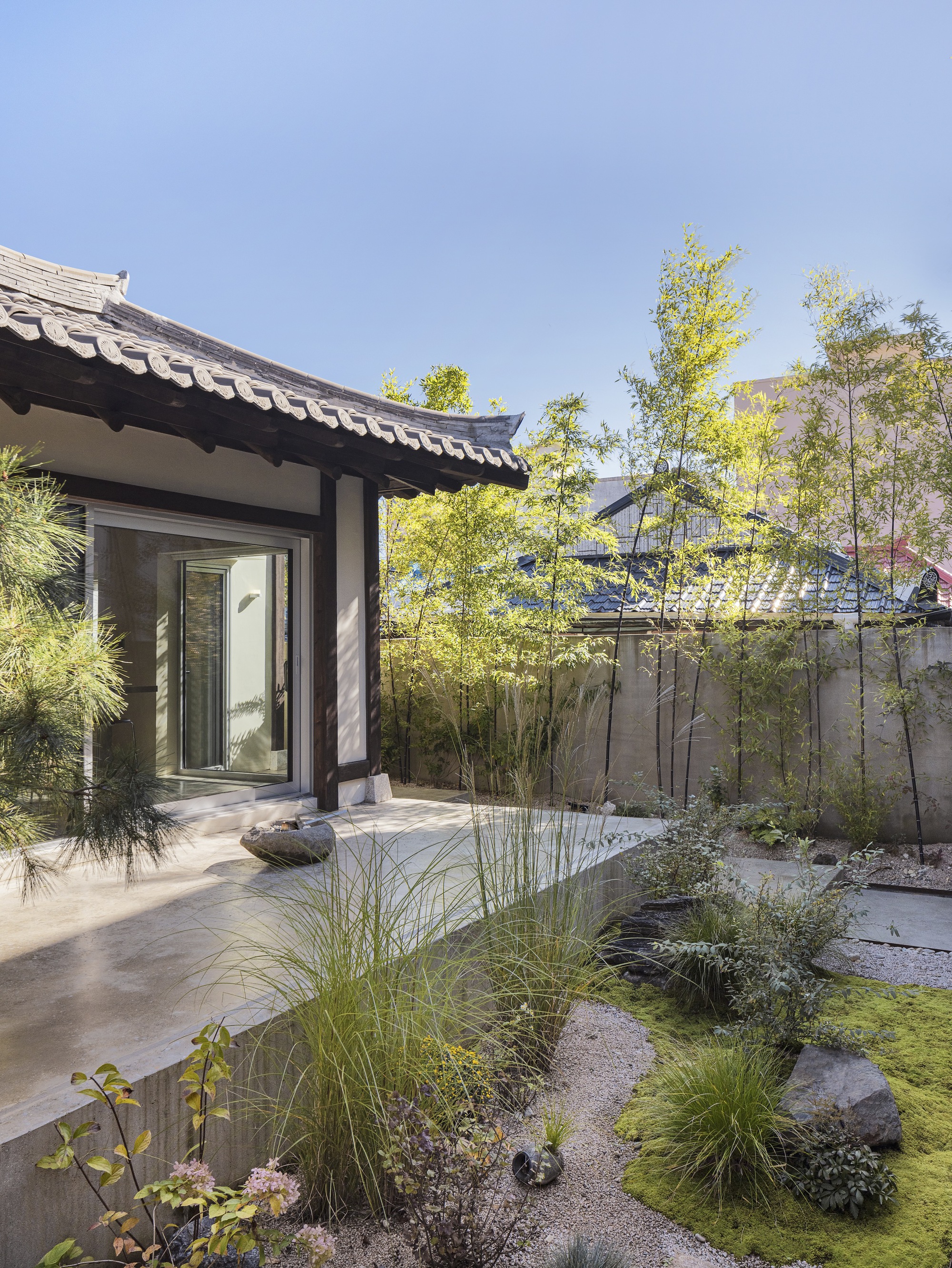 Courtyard garden with gravel, rocks, grasses and bamboo outside the entrance doorway
