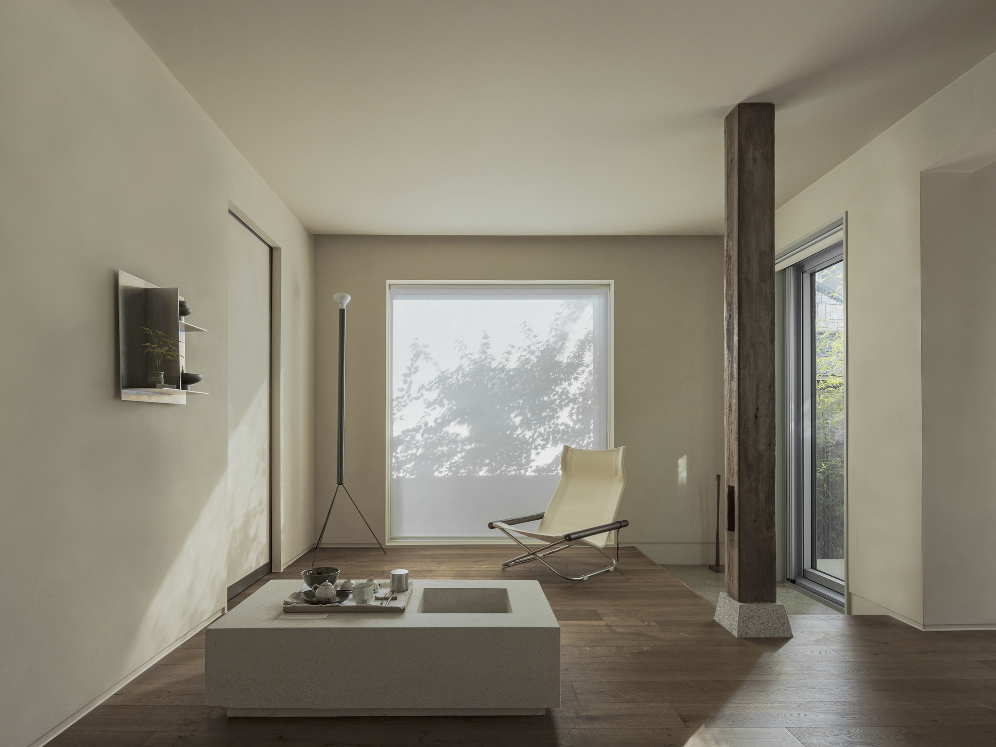 Living space with a low table, lounge chair, and translucent screen filtering tree shadows