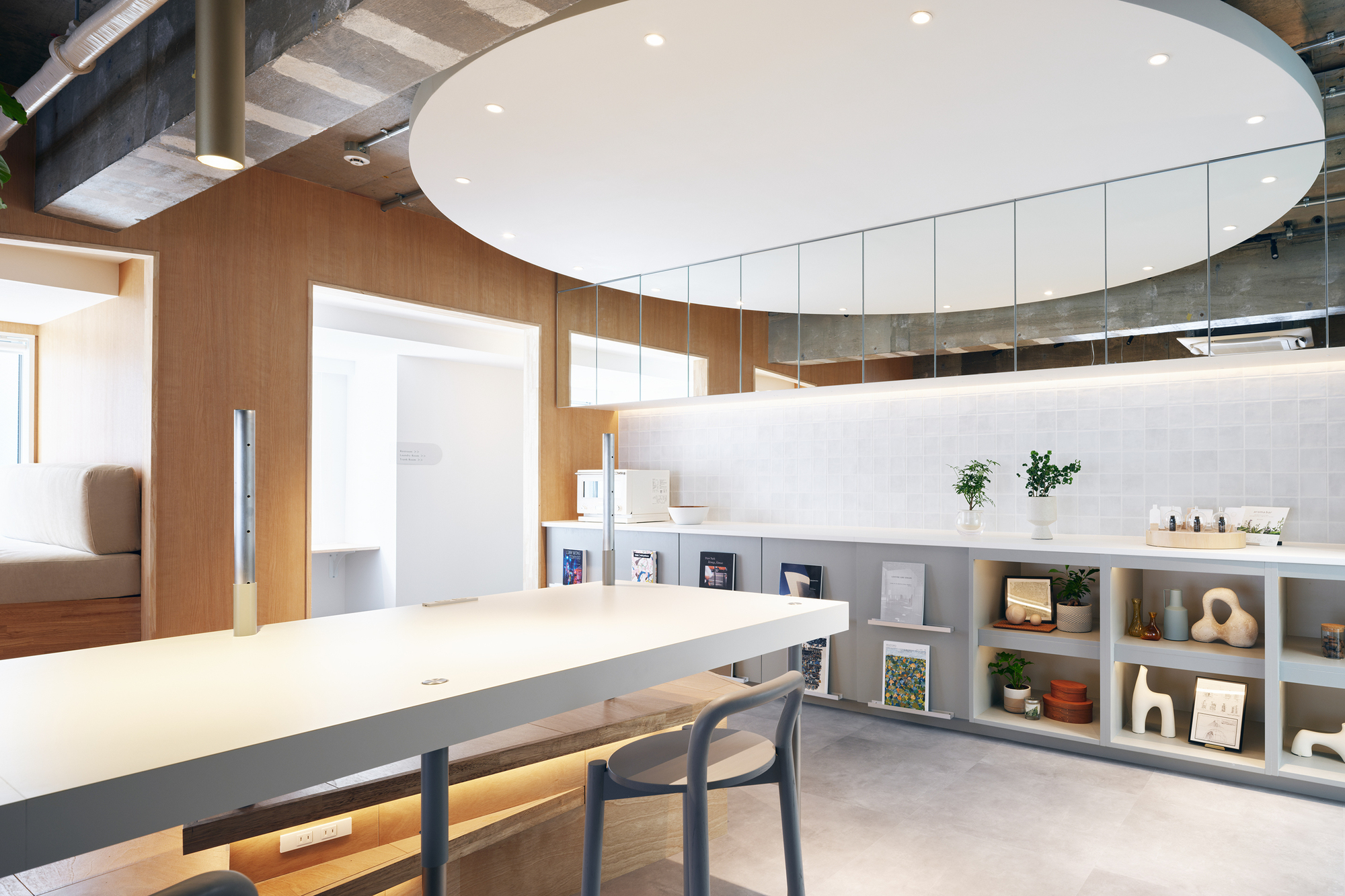 Kitchen counter with suspended white ceiling disc and open shelving below tiled backsplash