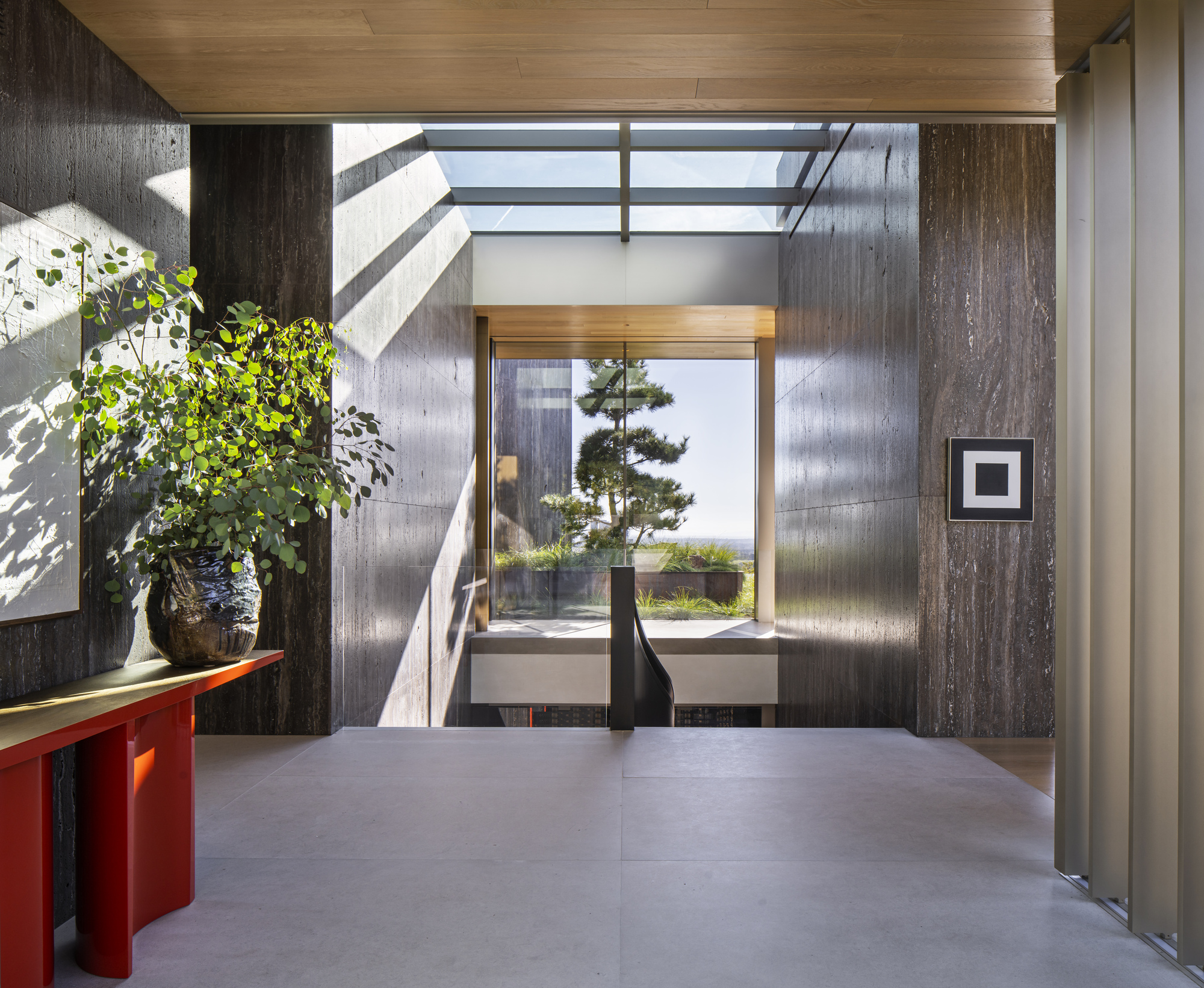 Entry foyer with board-formed concrete walls and clerestory opening casting diagonal shadows on the floor
