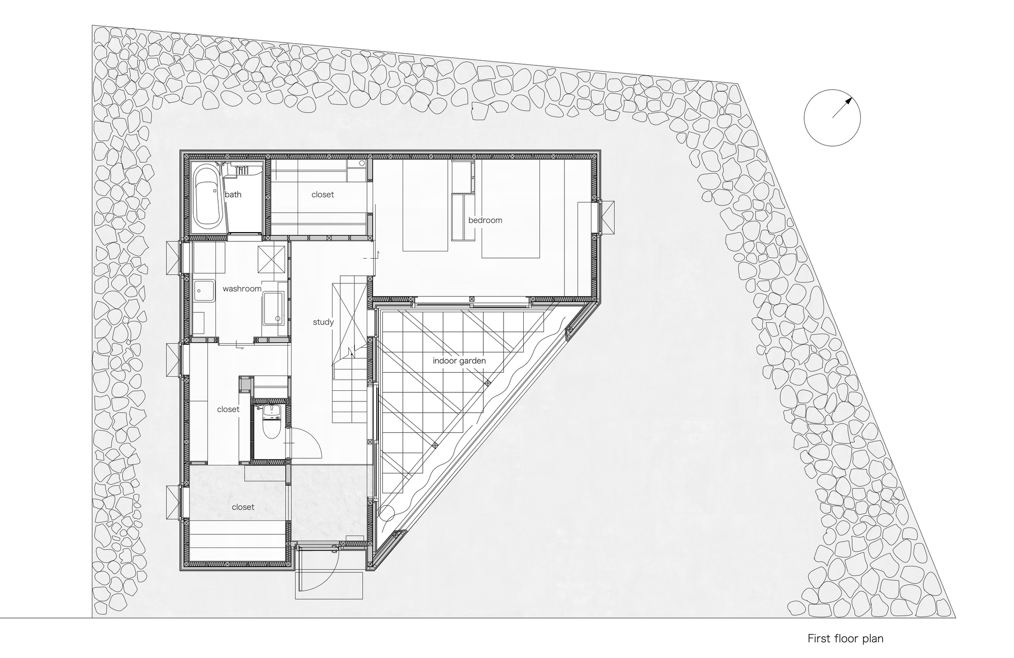 First floor plan drawing showing an angular residence with triangular courtyard and gravel perimeter landscaping