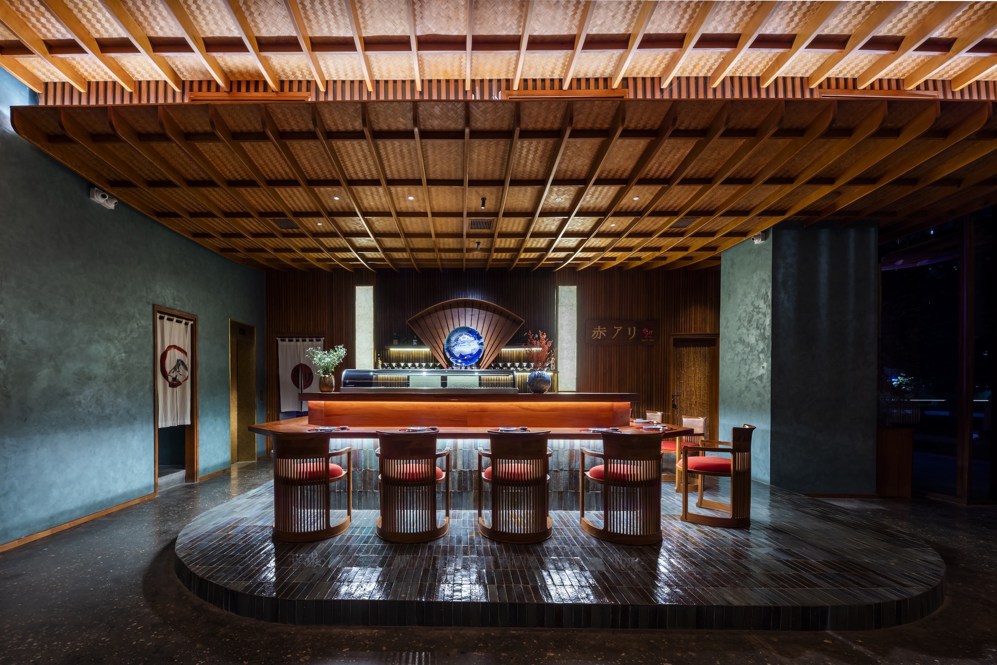 Bar area beneath gridded bamboo ceiling with raised platform, backlit counter and grey plaster walls