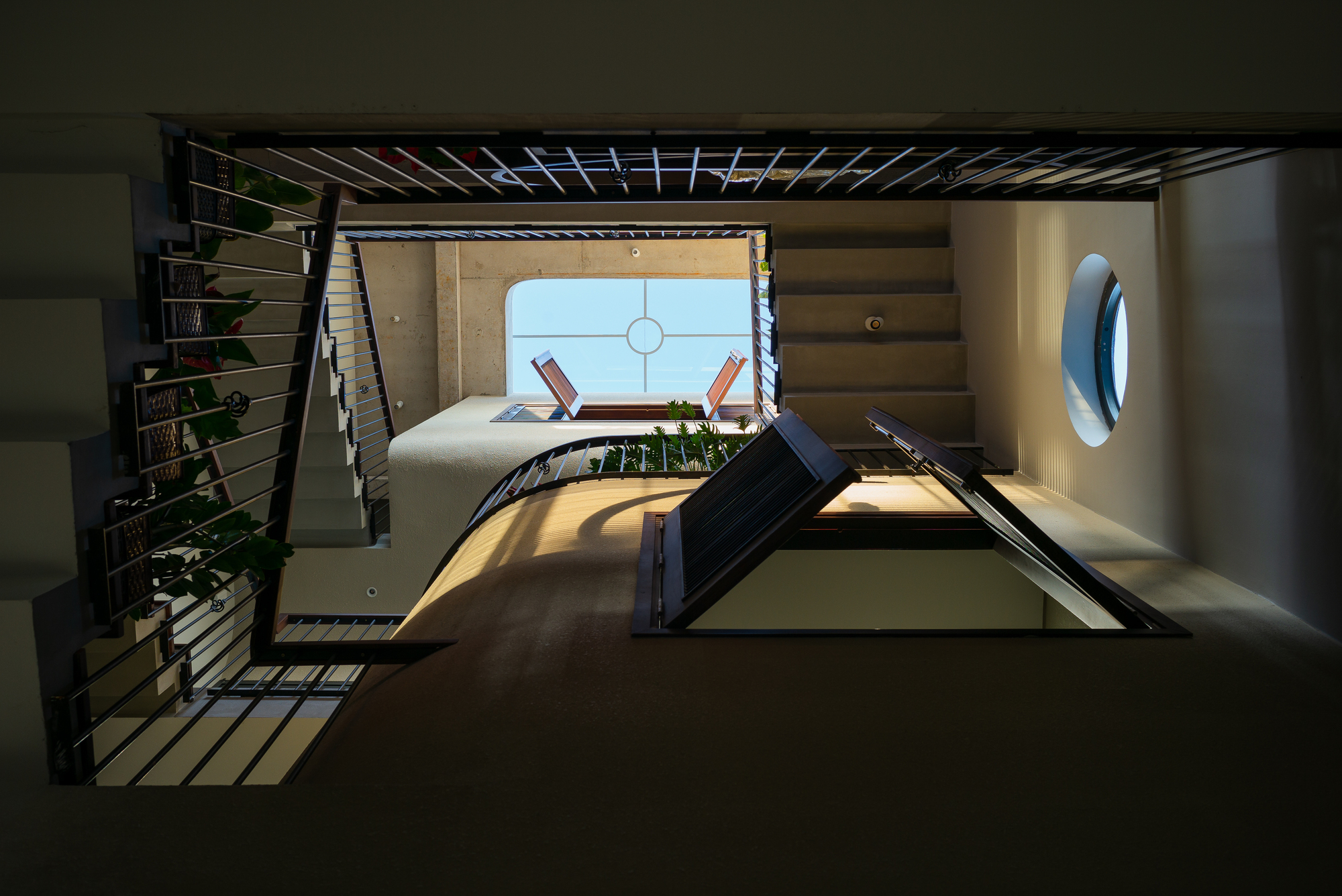 Looking up through the central atrium showing crossing bridges and circular skylights overhead