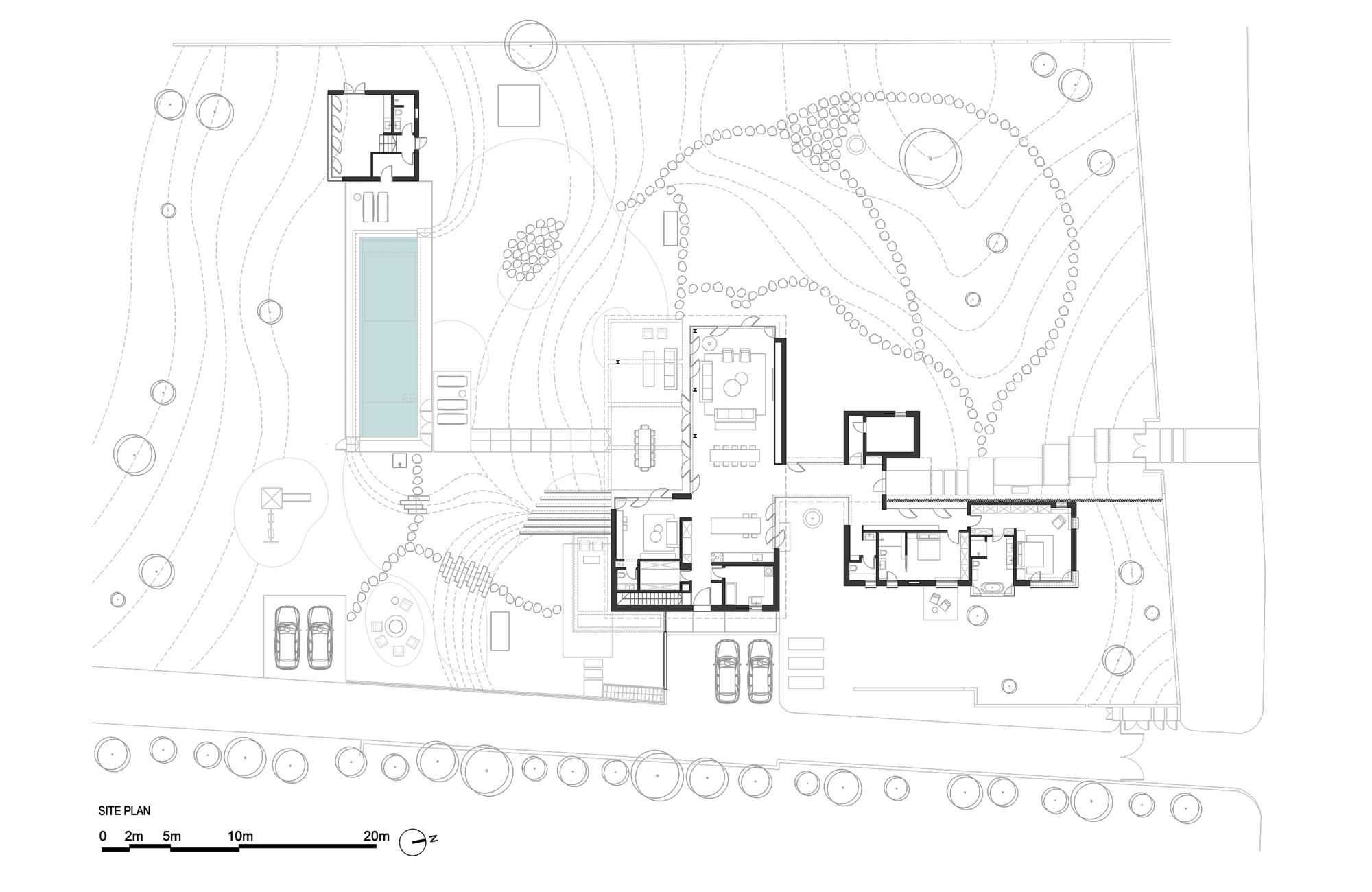 Site plan drawing showing dispersed building volumes around a pool and landscaped contours with trees