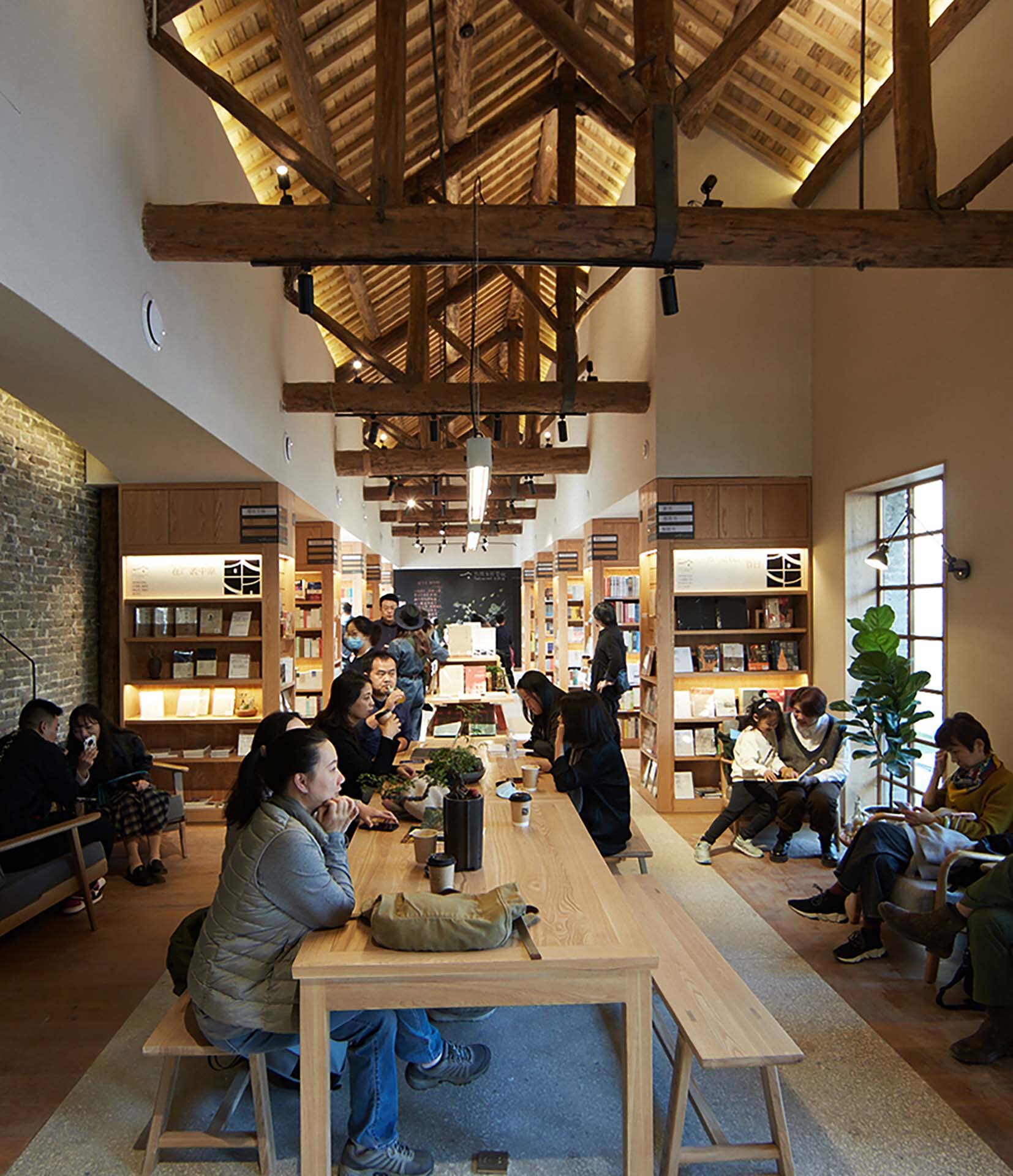 Central seating area with timber benches beneath vaulted ceiling with heavy timber beams and track lighting
