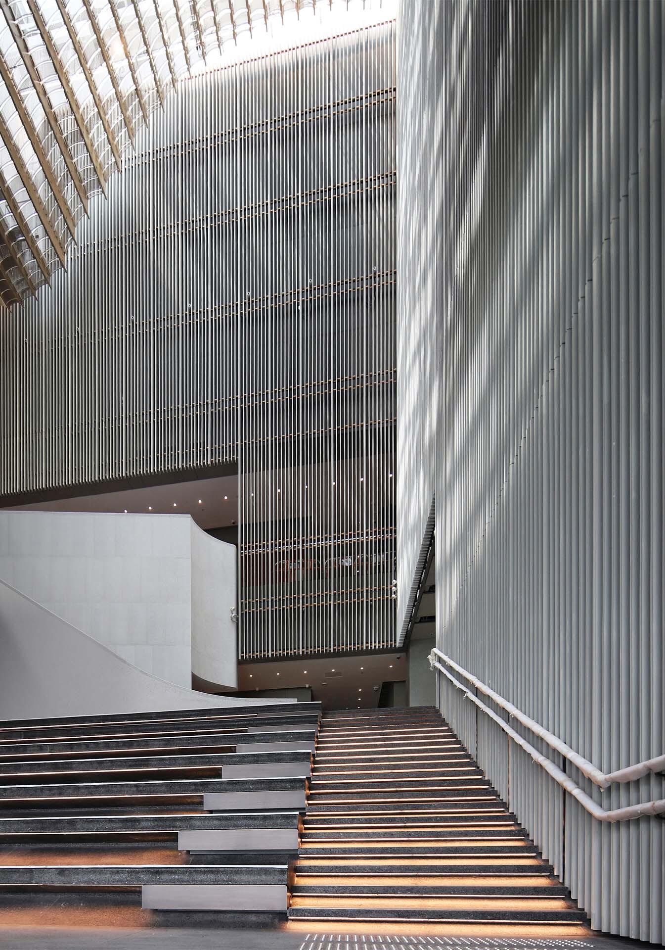 Timber staircase with integrated lighting leading up past vertical louvered wall surfaces
