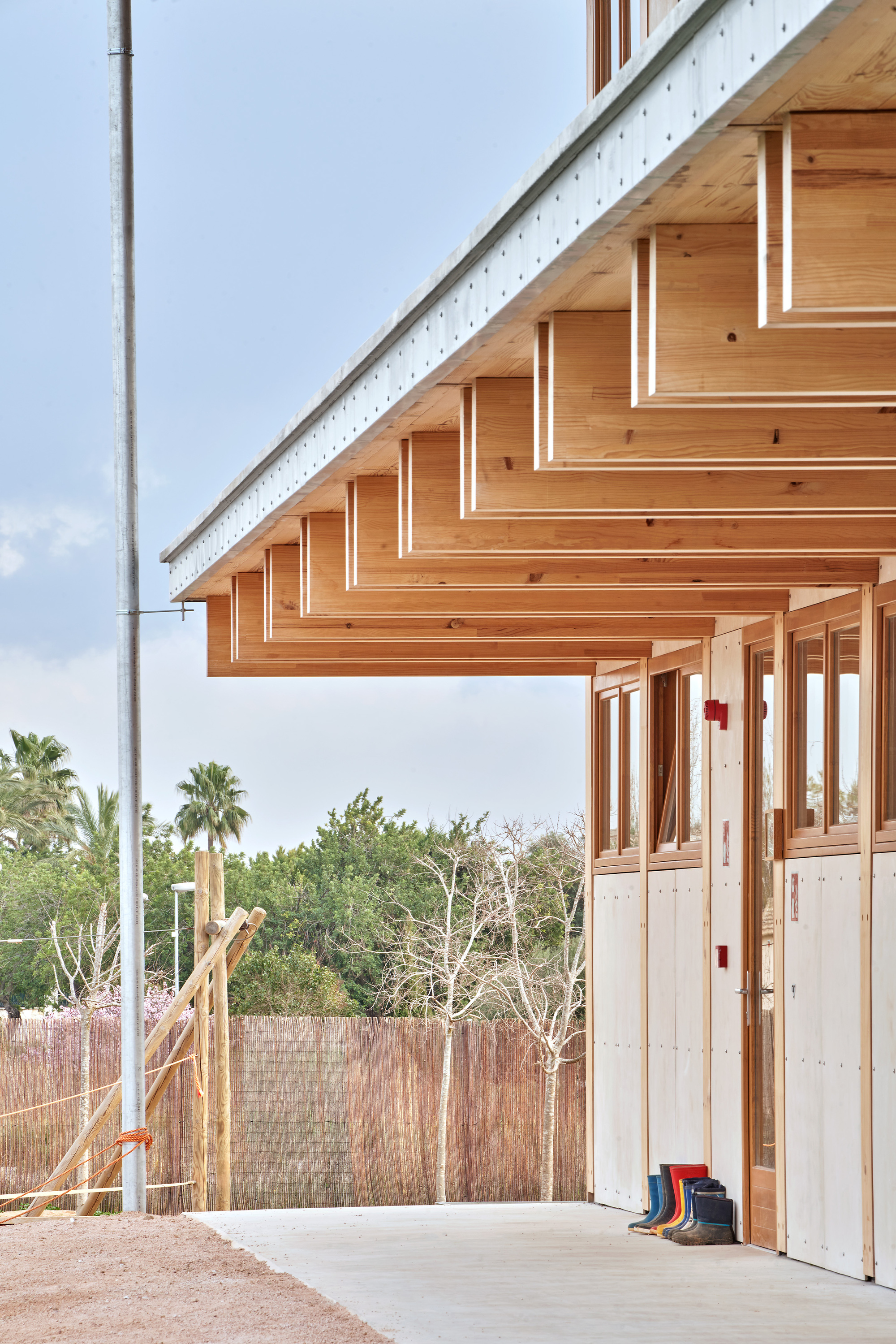 Cantilevered timber eaves with exposed rafters and beams above a covered walkway