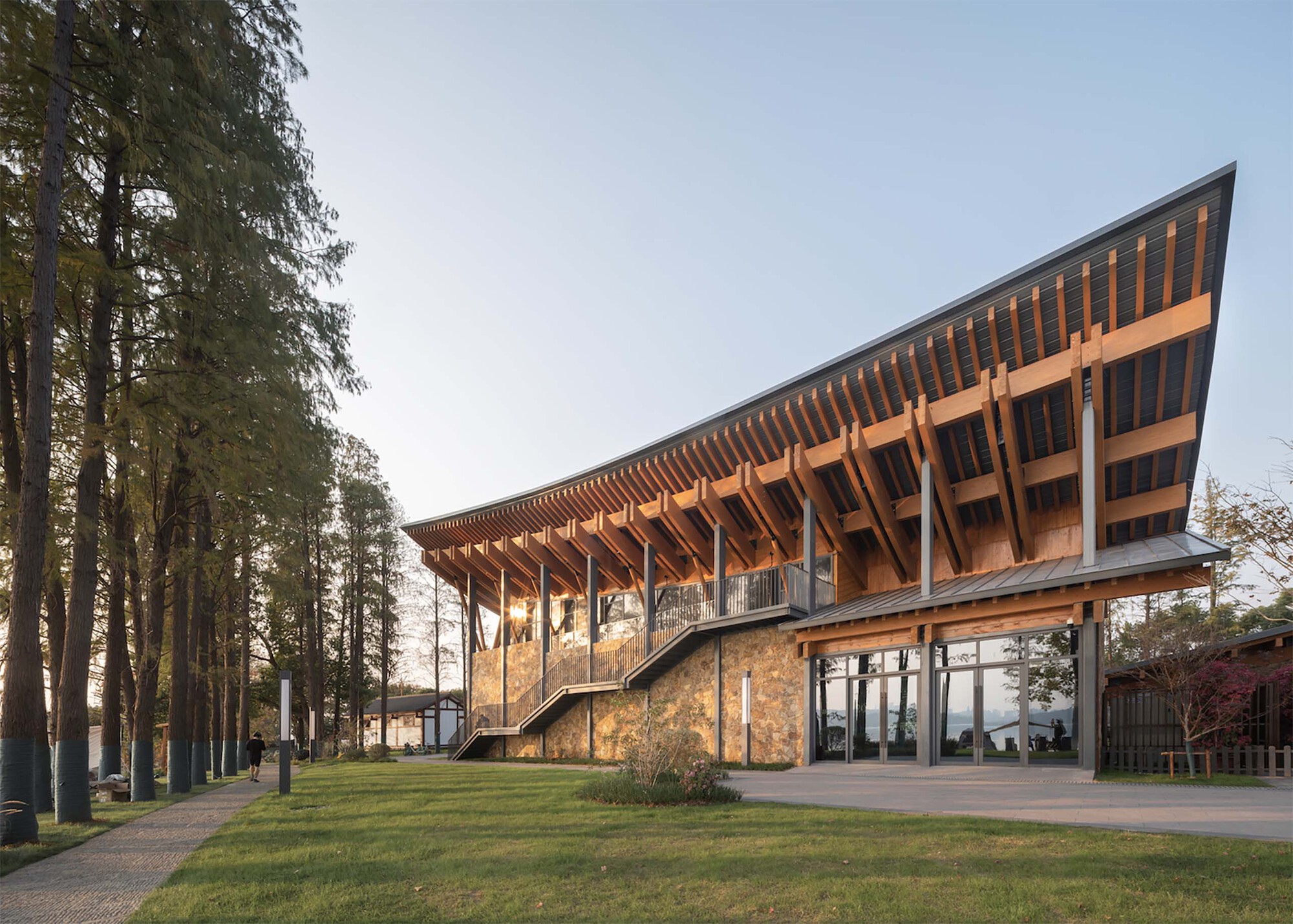 Side elevation showing angular timber roof rising above stone base with curved exterior staircase