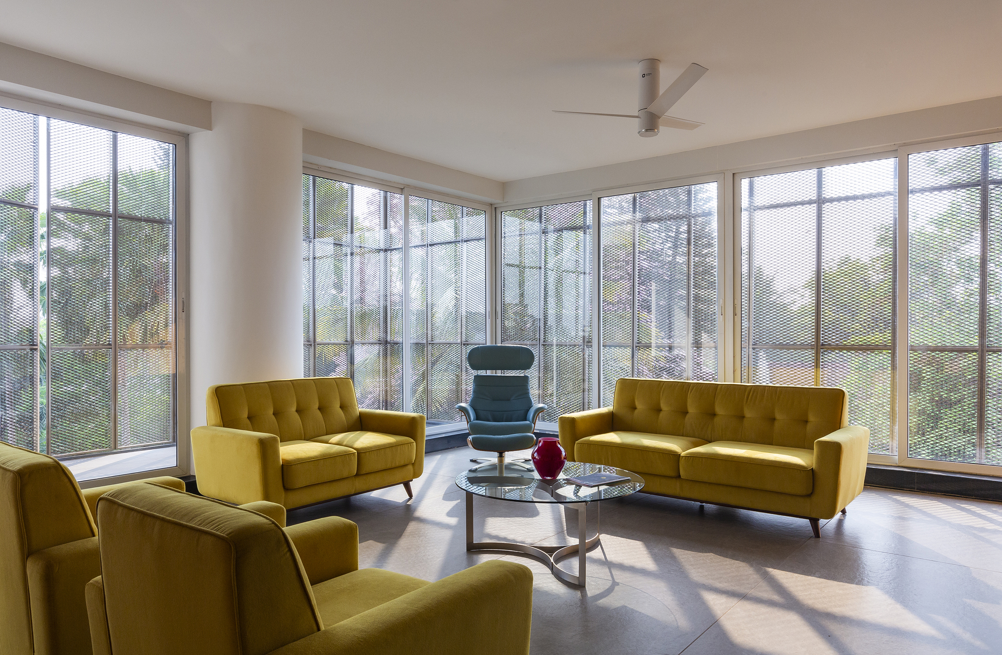 Corner living room with floor-to-ceiling glazing on two walls overlooking green landscape