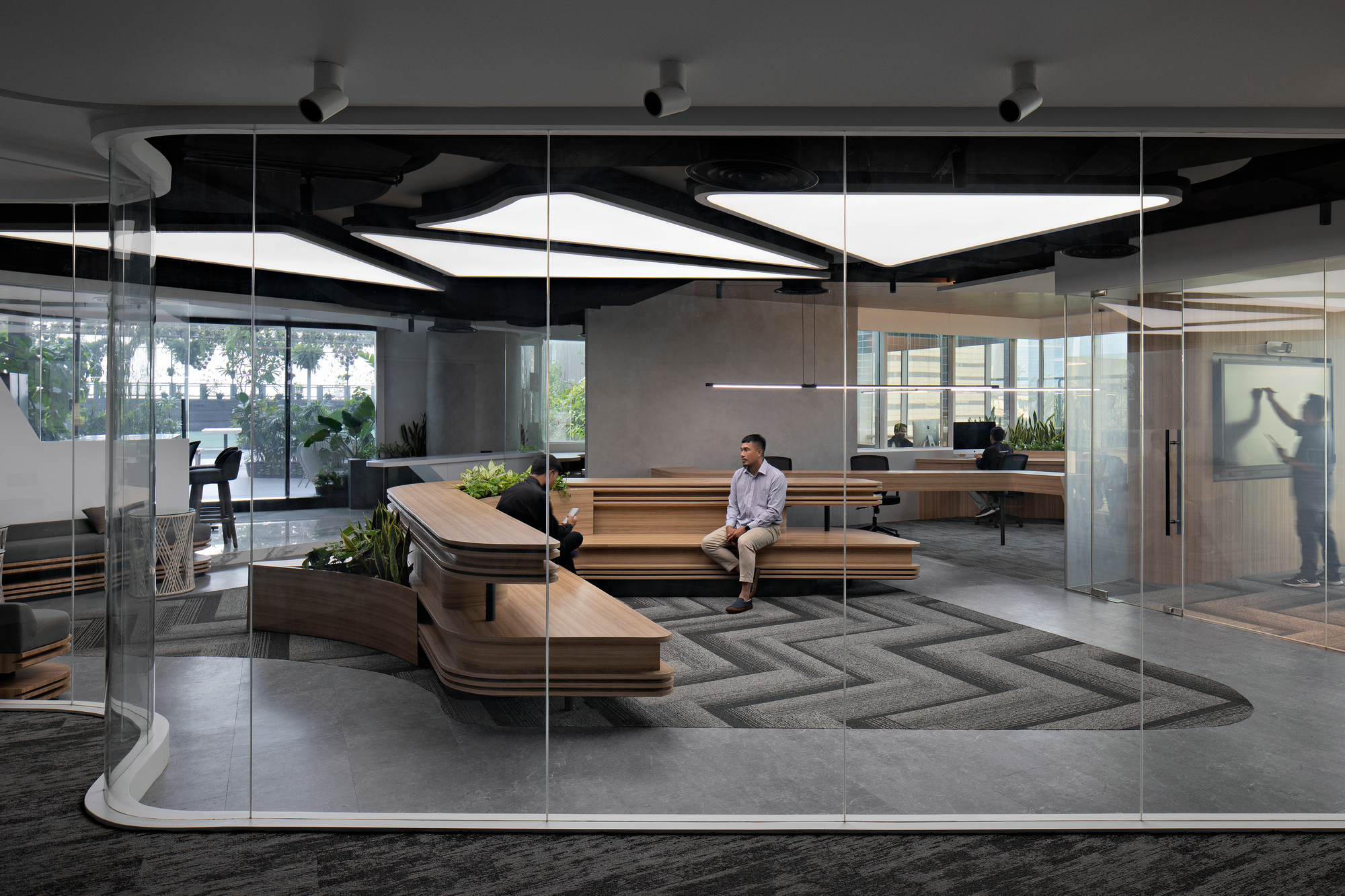 Reception lounge with tiered timber benches viewed through floor-to-ceiling glass wall