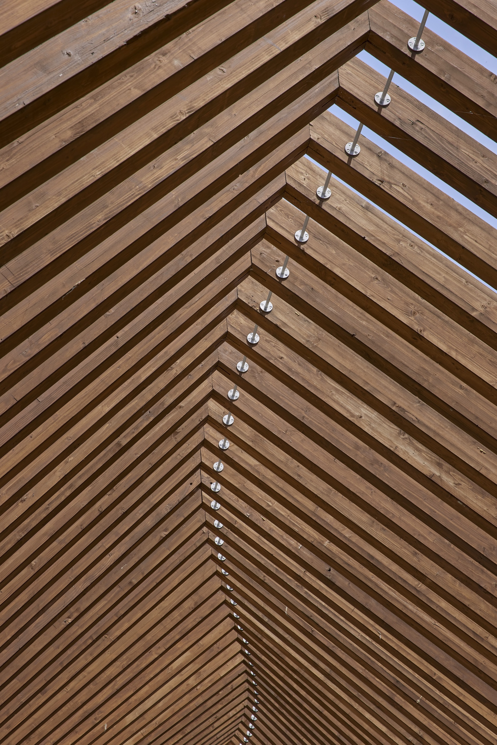 Close-up of the timber slat ceiling showing steel connectors along the ridge