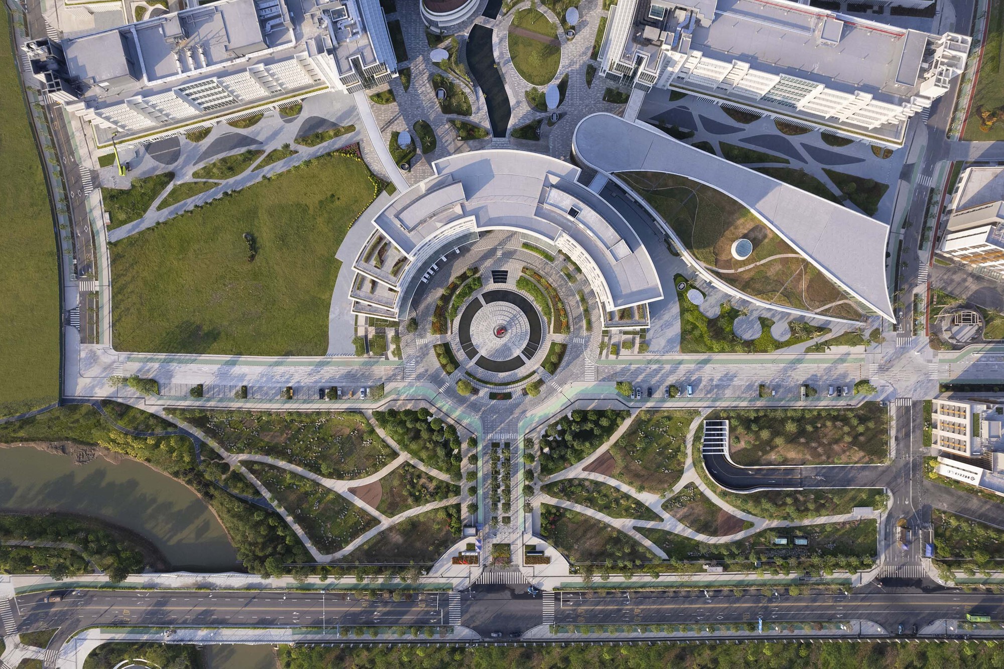 Drone view of circular plaza with concentric pavers leading to pedestrian pathways and green spaces