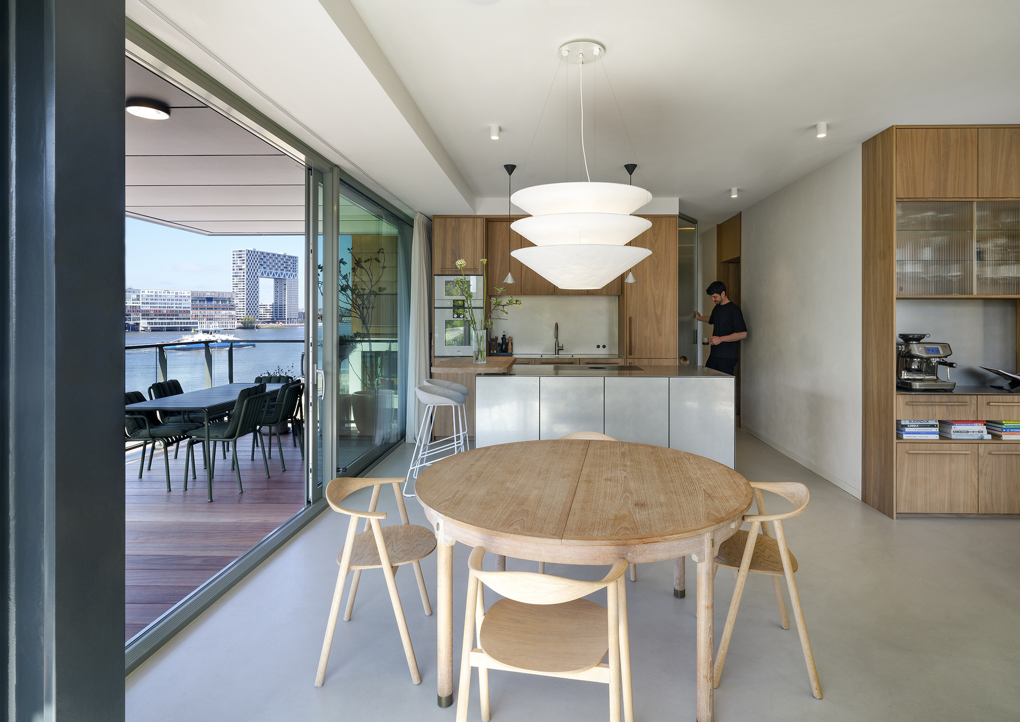 Open-plan kitchen and dining area with timber cabinetry and sliding doors to the balcony