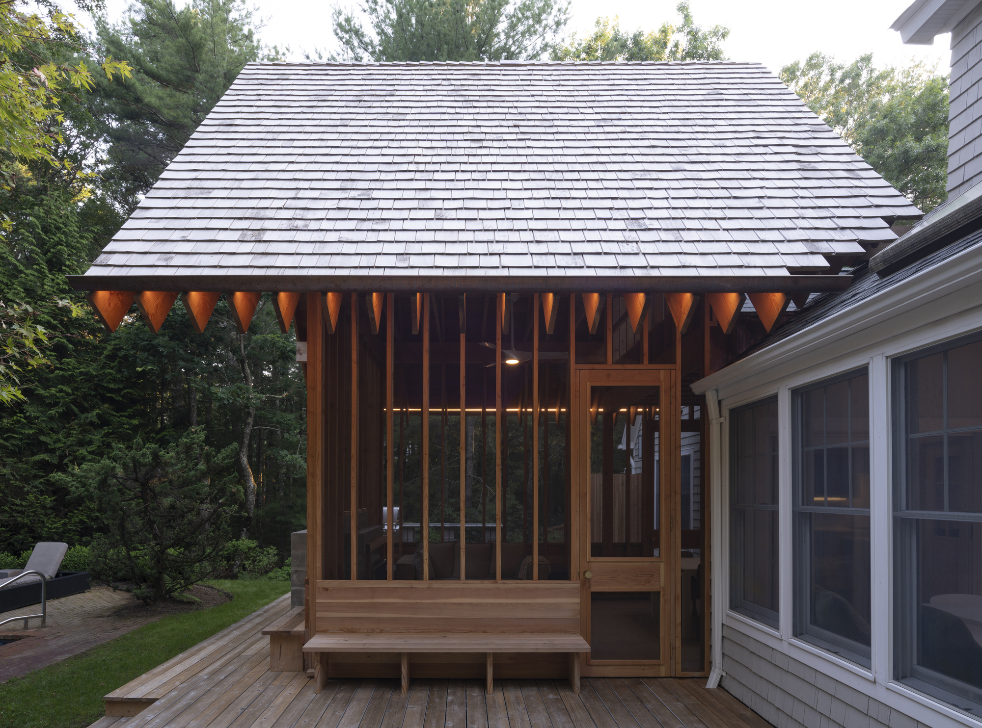 Close-up of the timber pavilion roof eave with exposed rafter tails and vertical wood screen