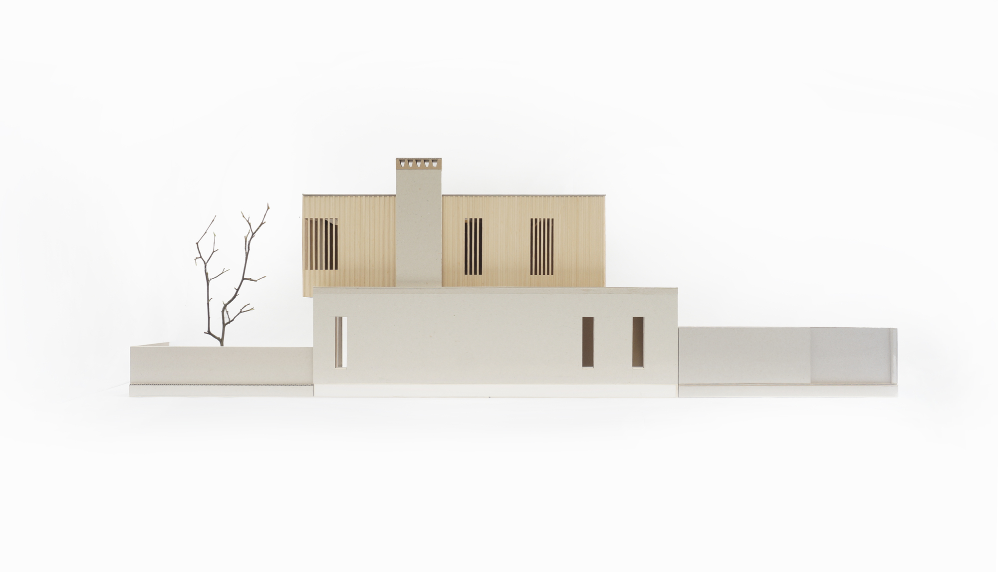Physical model of the front elevation showing stacked volumes with vertical slatted openings and miniature tree