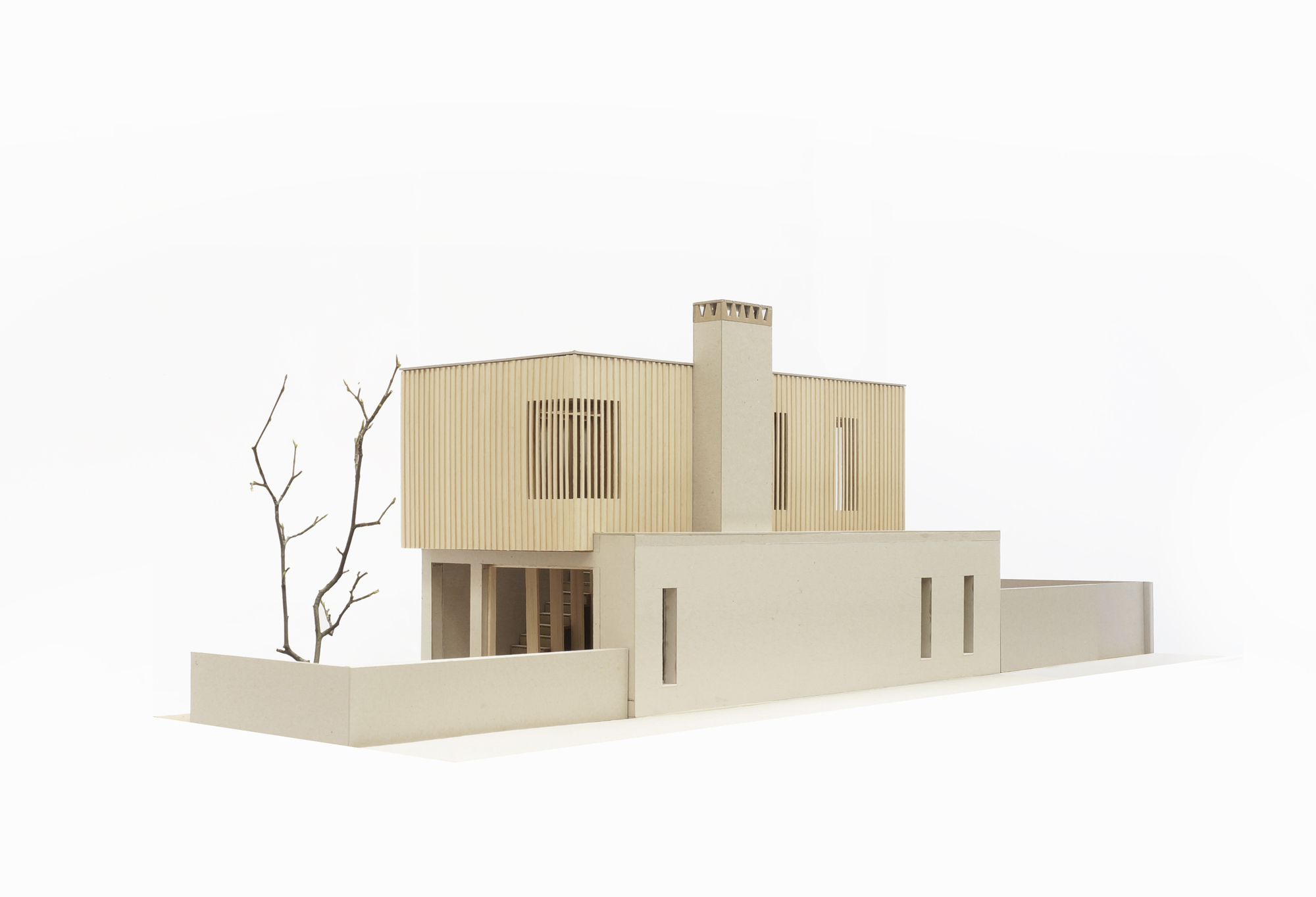 Physical model from corner view displaying stacked massing with timber cladding and courtyard walls