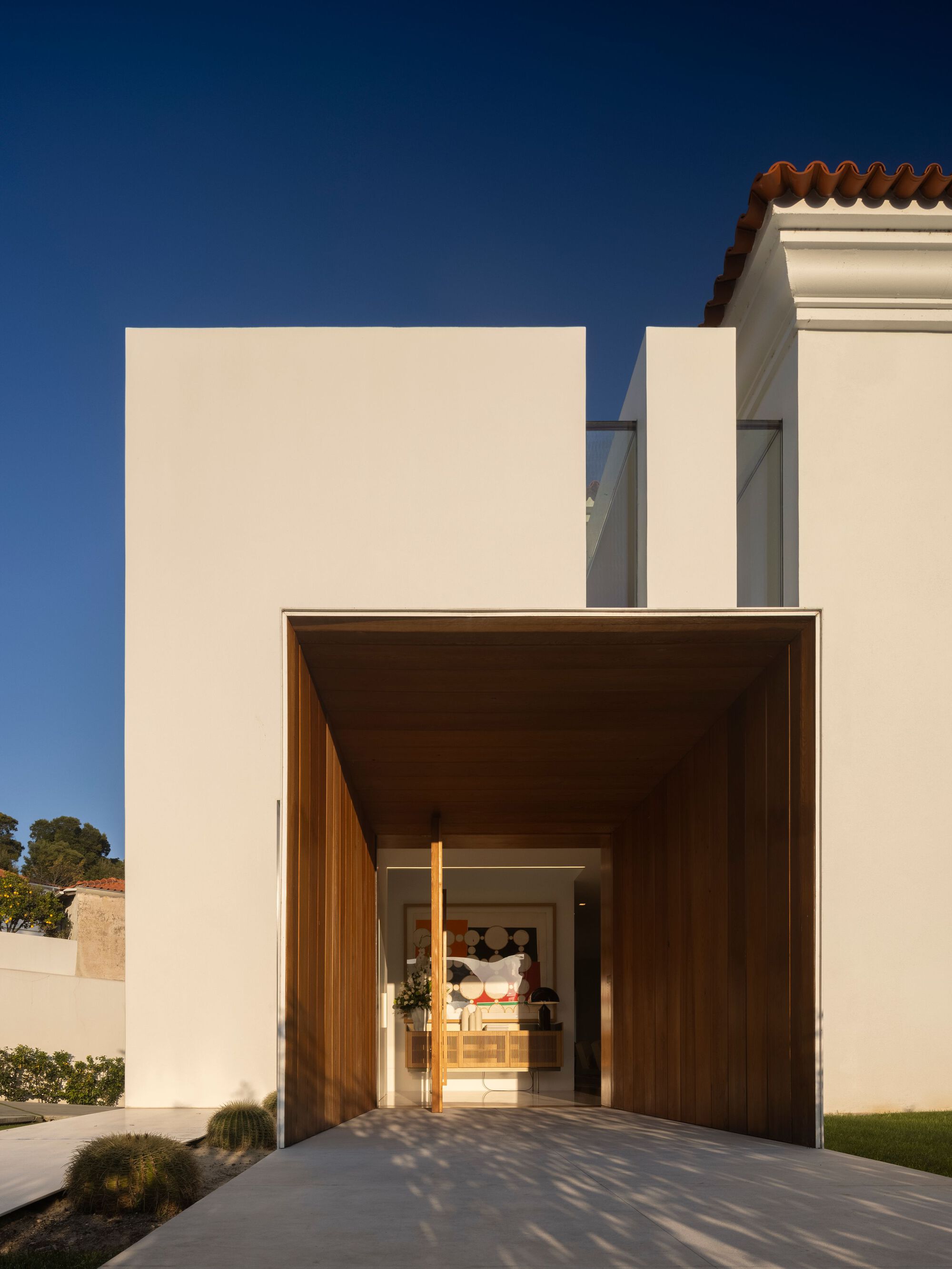 Timber-lined entry portal framing the front door with a view through to the interior