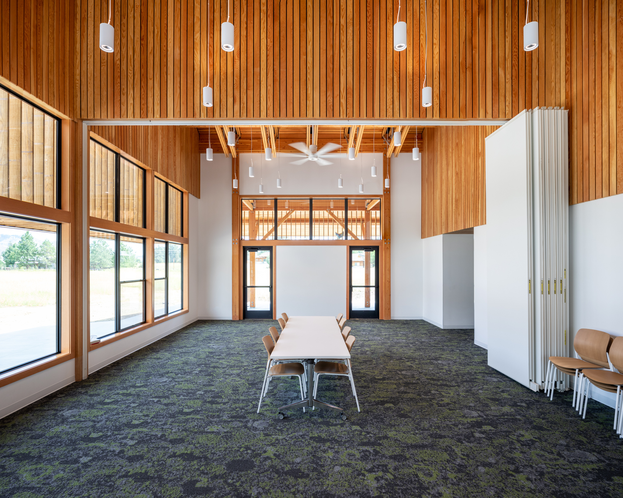 Multipurpose room with vertical wood slat ceiling and clerestory windows above white walls