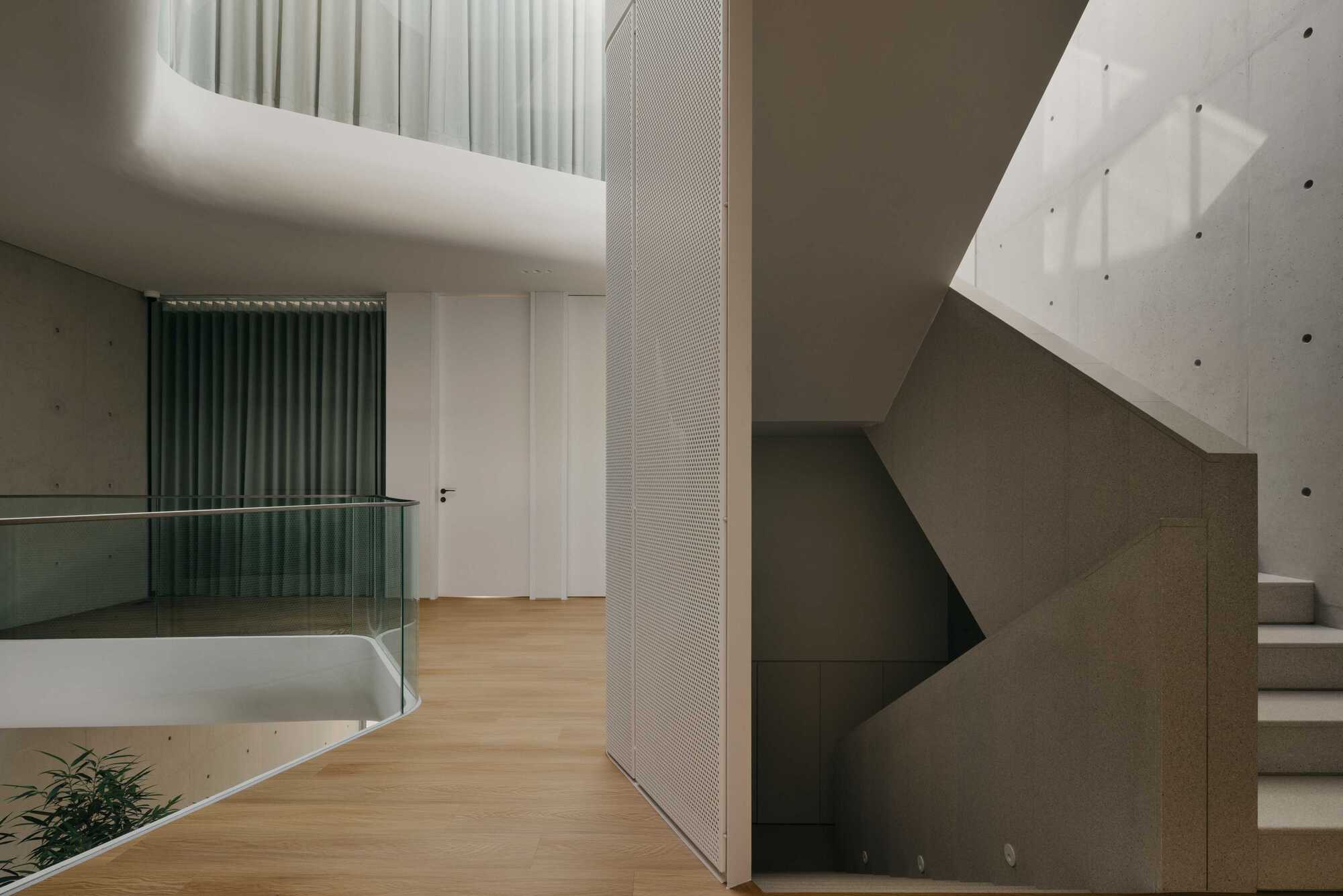 Upper level hallway with perforated metal panels, timber flooring and clerestory skylights above