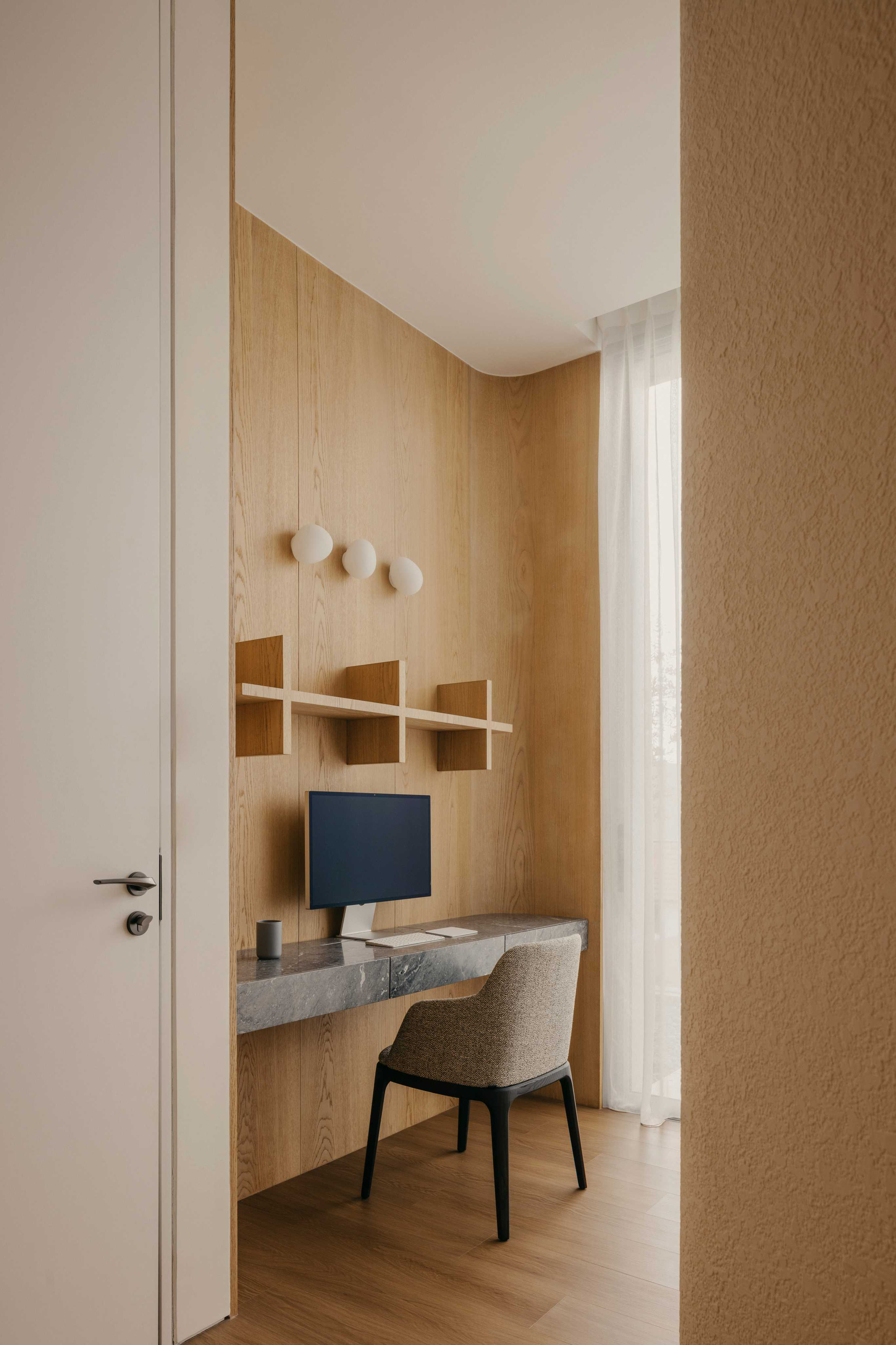 Built-in timber desk nook with floating shelves and three wall hooks in soft daylight